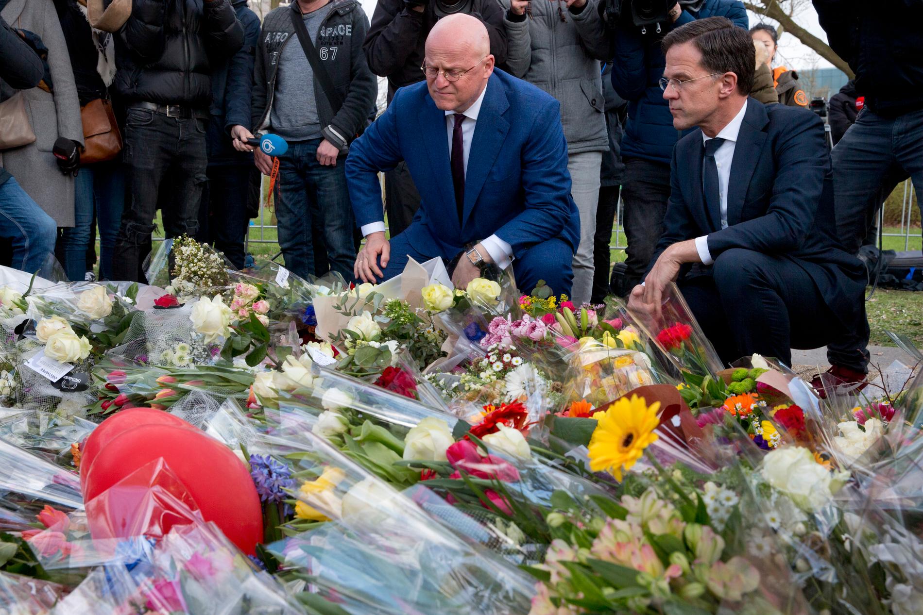 Nederländernas premiärminister Mark Rutte (till höger) och justitieminister Ferd Grapperhaus lägger blommor på 24 oktobertorget i Utrecht. I måndags sköts tre människor ihjäl på en spårvagn i staden.