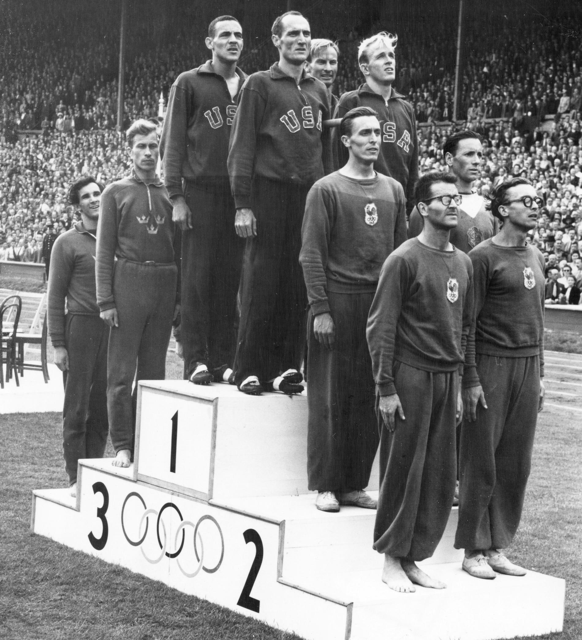 Folke Alnevik, näst längst till vänster, på pallen på Wembleys innerplan efter OS-bronset 1948.
