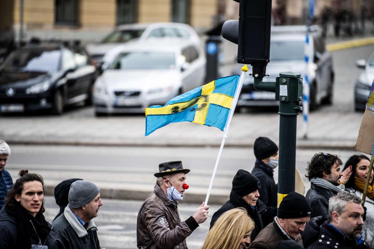 Man med clownnäsa demonstrerar i Stockholm.