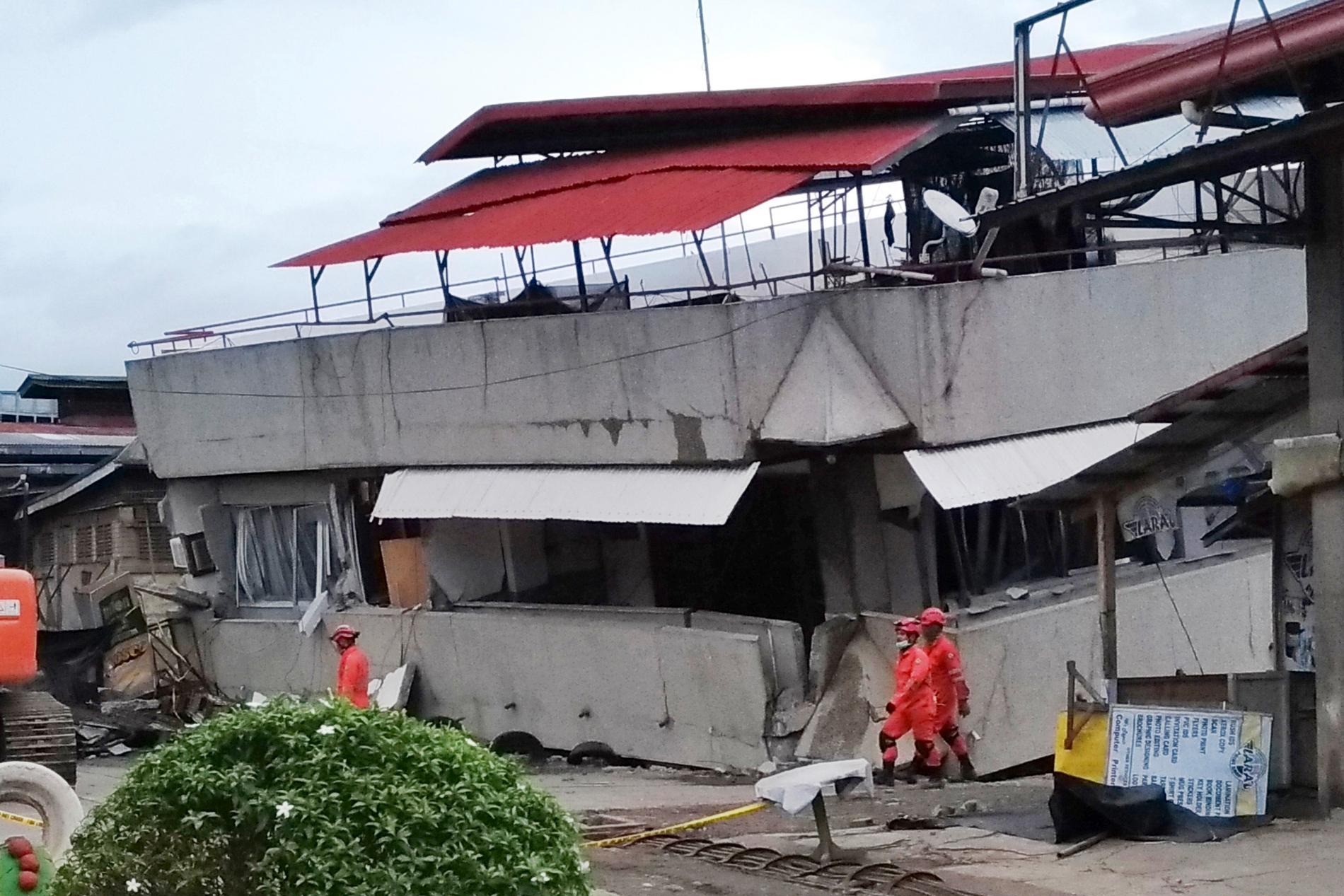 Räddningsarbetare vid en kollapsad trevåningsbyggnad i Padada i provinsen Davao del Sur under måndagen.