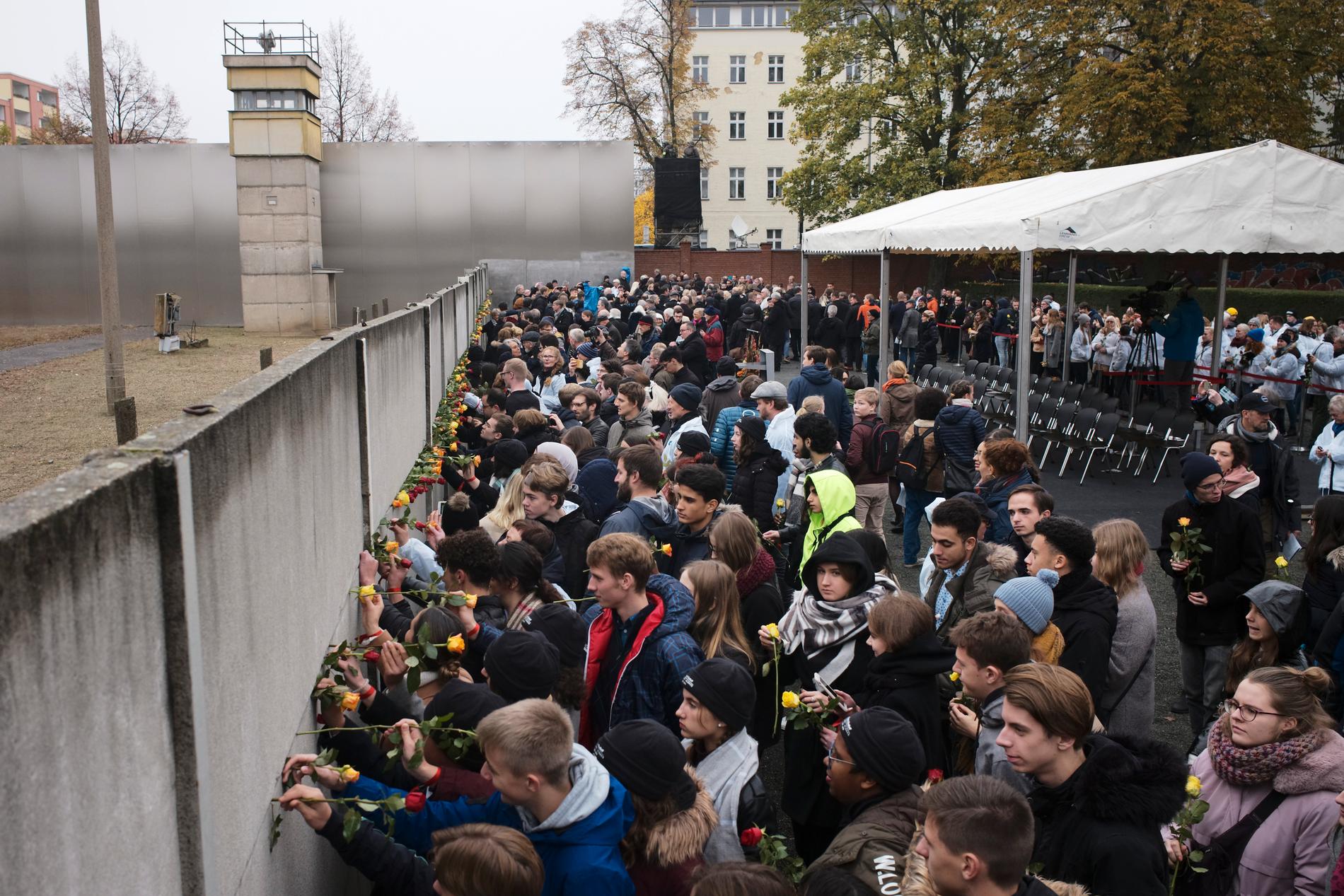 Minnesdagen av Berlinmurens fall inleddes på Bernauer Strasse i Berlin. Människor placerade symboliskt blommor i en av de sista kvarvarande delarna av muren.
