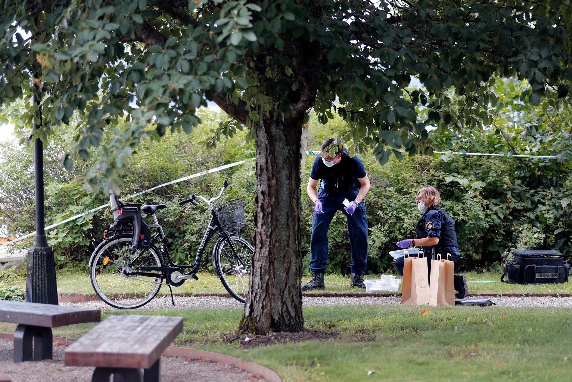 Police crime scene investigators work in a park close to the cathedral.
