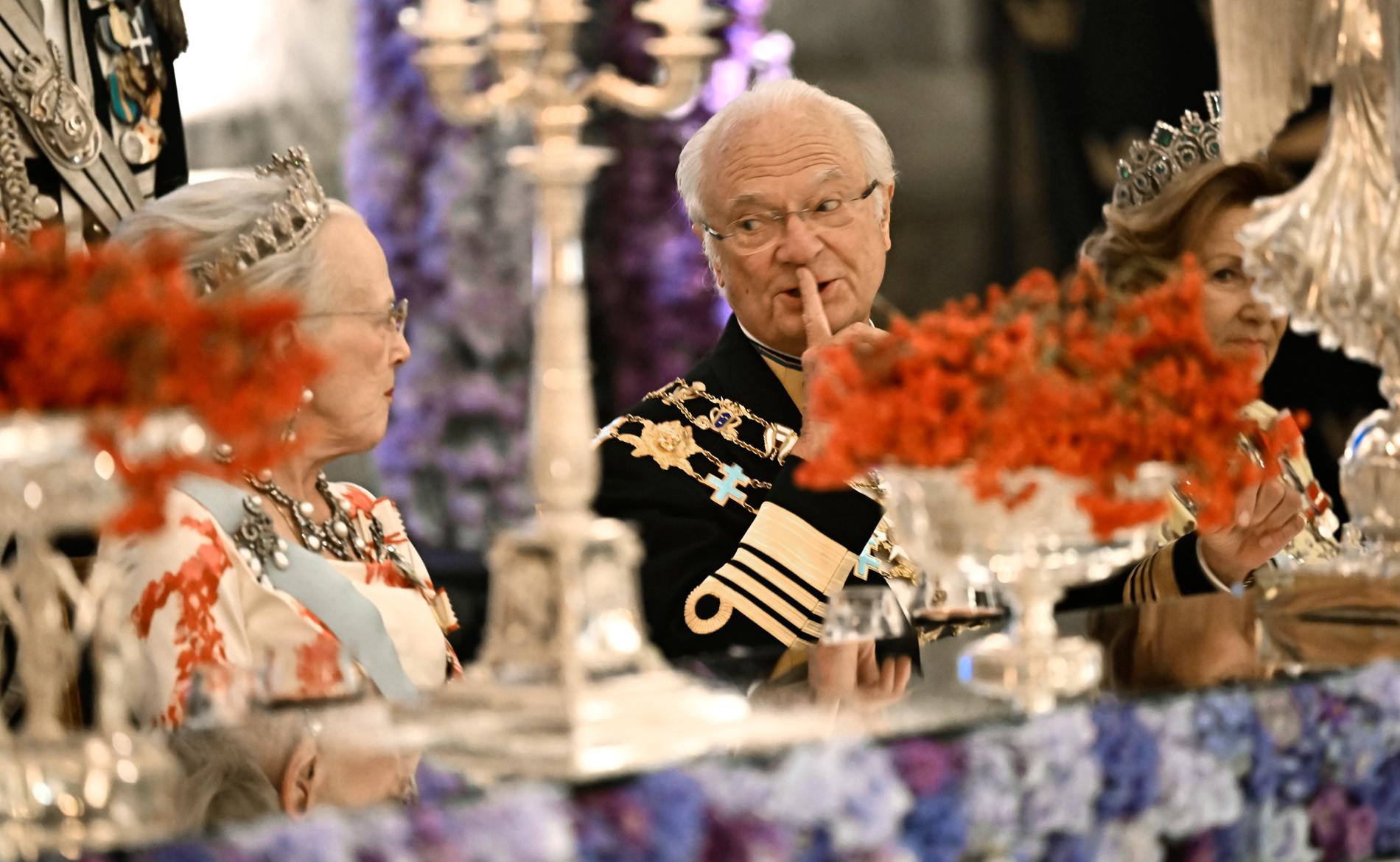 Kung Carl Gustaf lär inte följa i drottning Margrethes fotspår och abdikera. Här dinerar regenterna på Stockholms slott. Till höger skymtar Norges drottning Sonja.