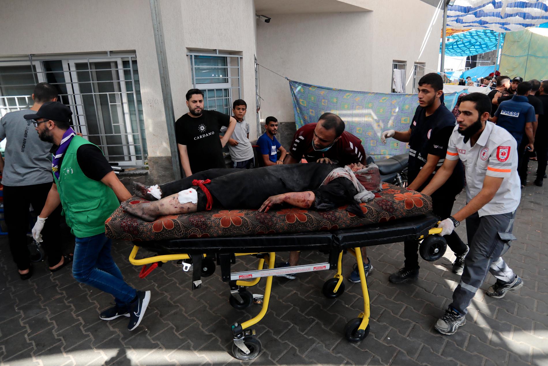 En skadad kvinna rullas in på bår till al-Shifa-sjukhuset.
