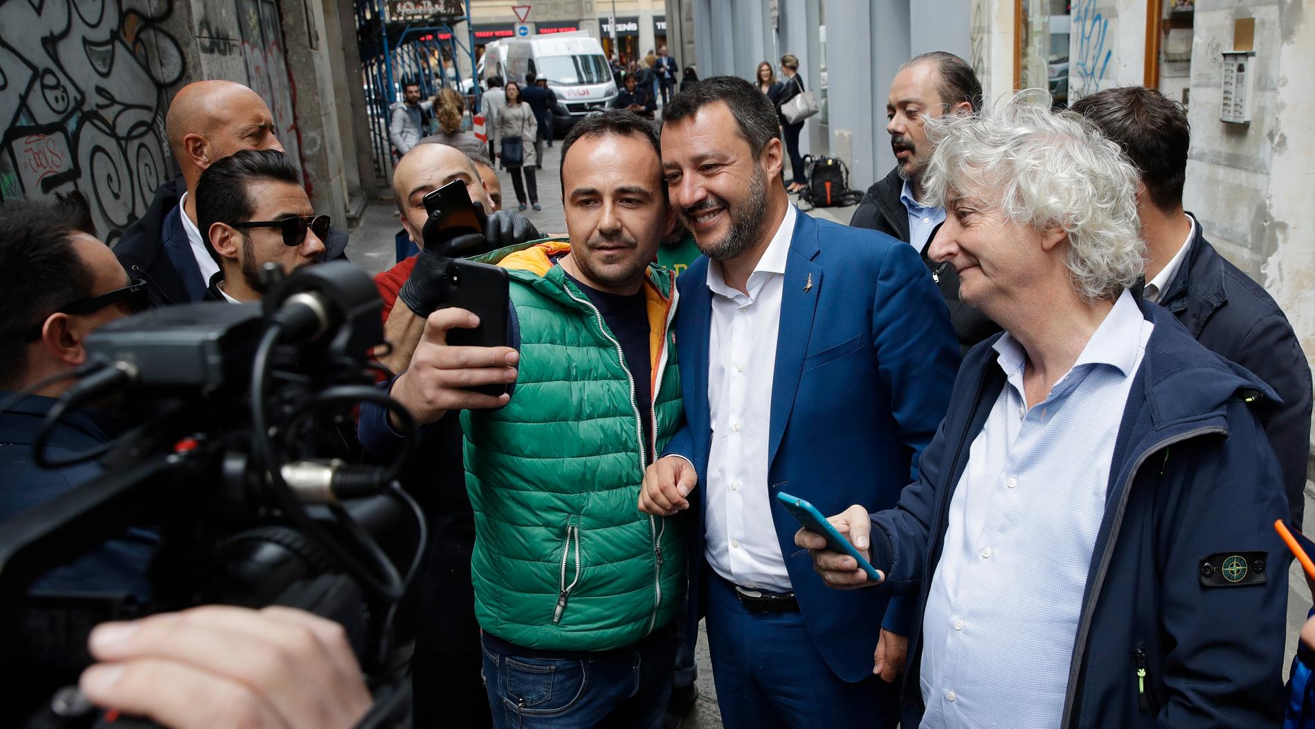 Italiens inrikesminister och vice premiärminister Matteo Salvini i blå kavaj ställer upp på selfies i samband med att han ska hålla en presskonferens i Milano.