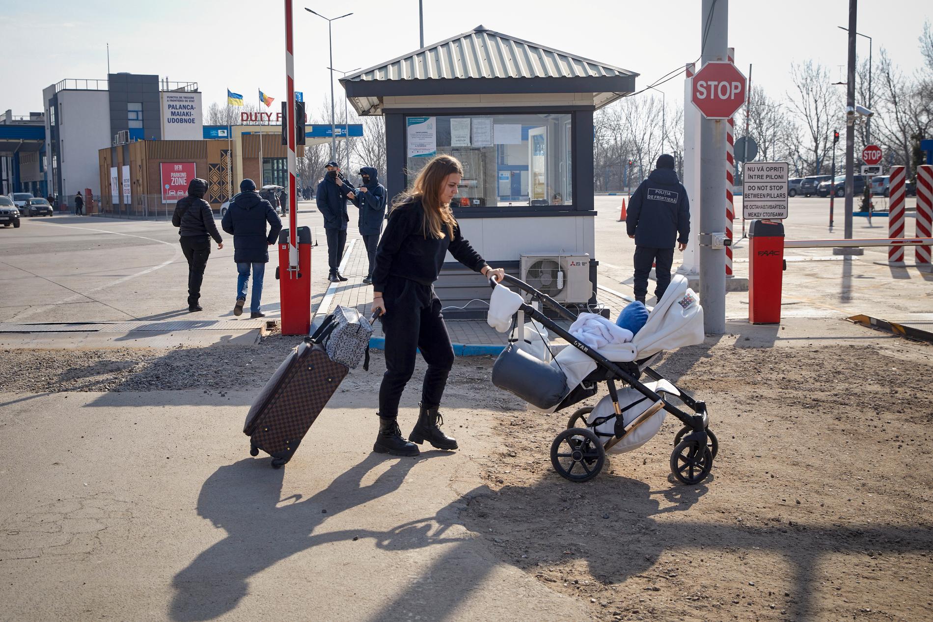 En kvinna med barnvagn passerar gränsen mellan Ukraina och Moldavien på lördagen.