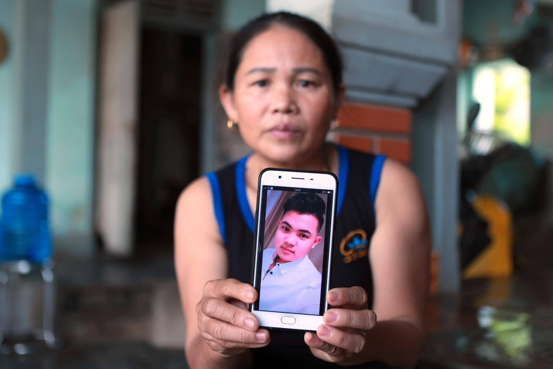 Hoang Thi Ai visar en bild på sin son som befaras vara en av de personer som hittades död i lastbilen utanför London. Migranter betalar flyktingsmugglare upp till en halv miljon kronor för att ta sig från Vietnam till Storbritannien.