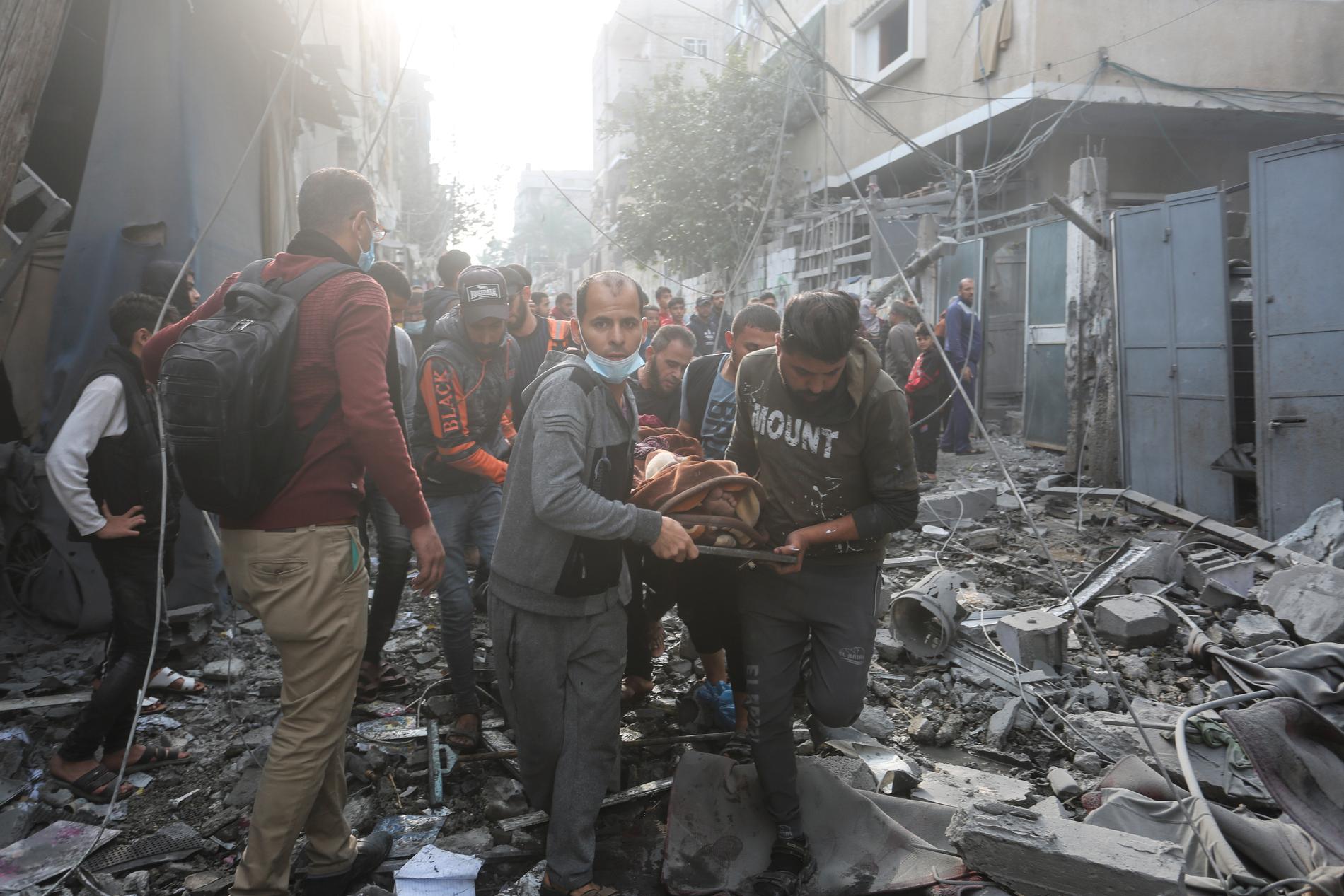 Palestinier evakuerar skadade efter israeliska attacker i Rafah på Gazaremsan, 1 december. 