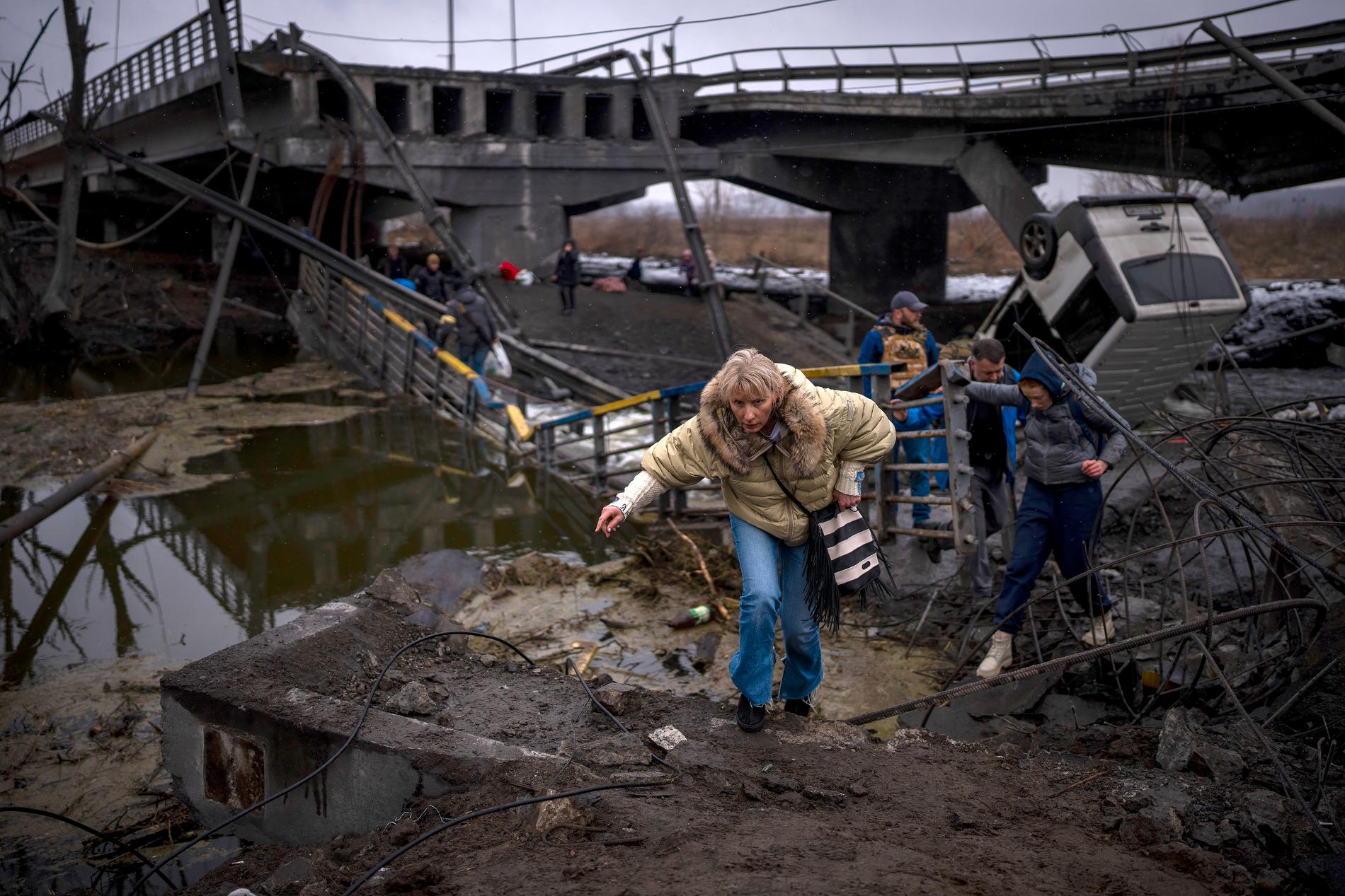En kvinna springer över en förstörd bro i utkanterna av Kiev på onsdagen. 