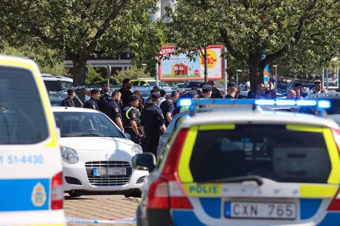 Poliser på plats i Hjällbo efter en dödsskjutning, två dagar innan det våldsamma upploppet. 