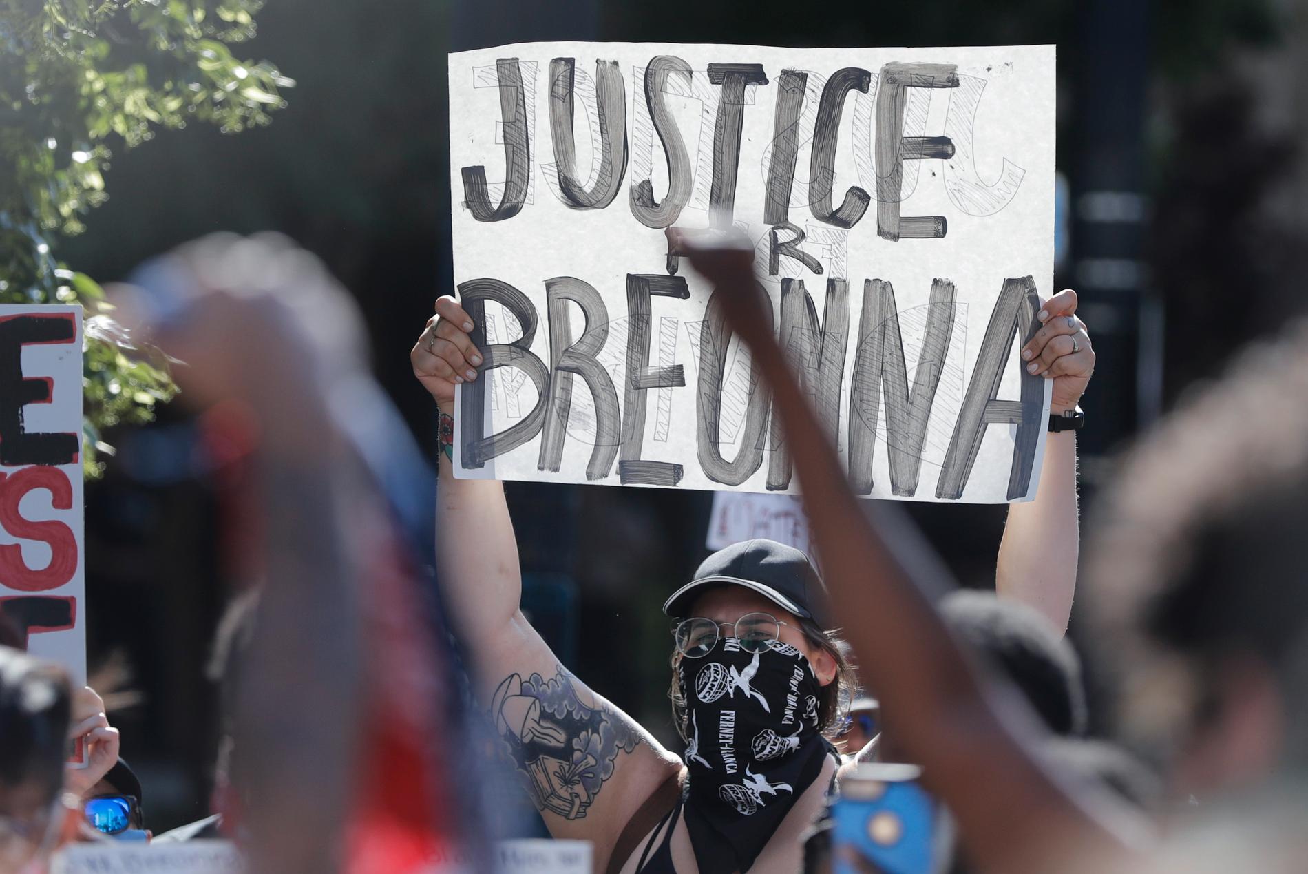 En demonstrant håller upp ett plakat med texten "Rättvisa för Breonna" i Louisville.