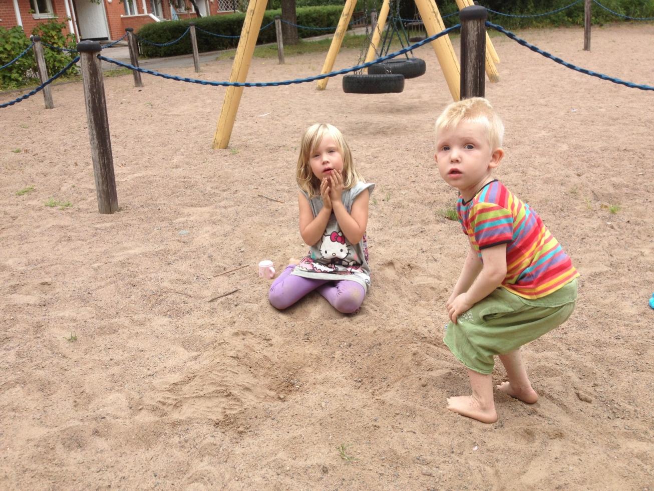 Cassandra och Zacharias leker i sanden.