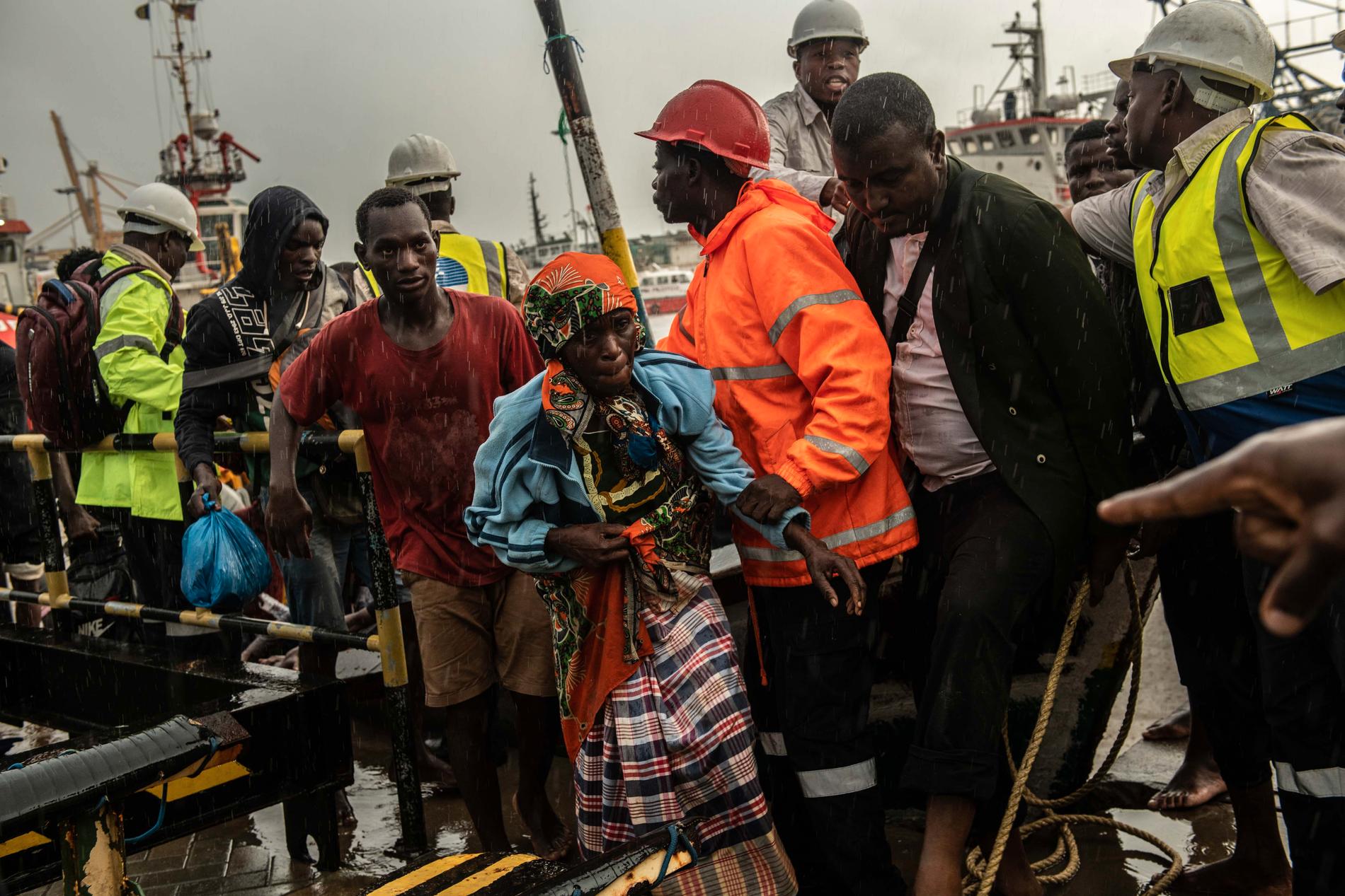Folk från staden Buzi får hjälp efter att de anlänt med båt till Beira i Moçambique.
