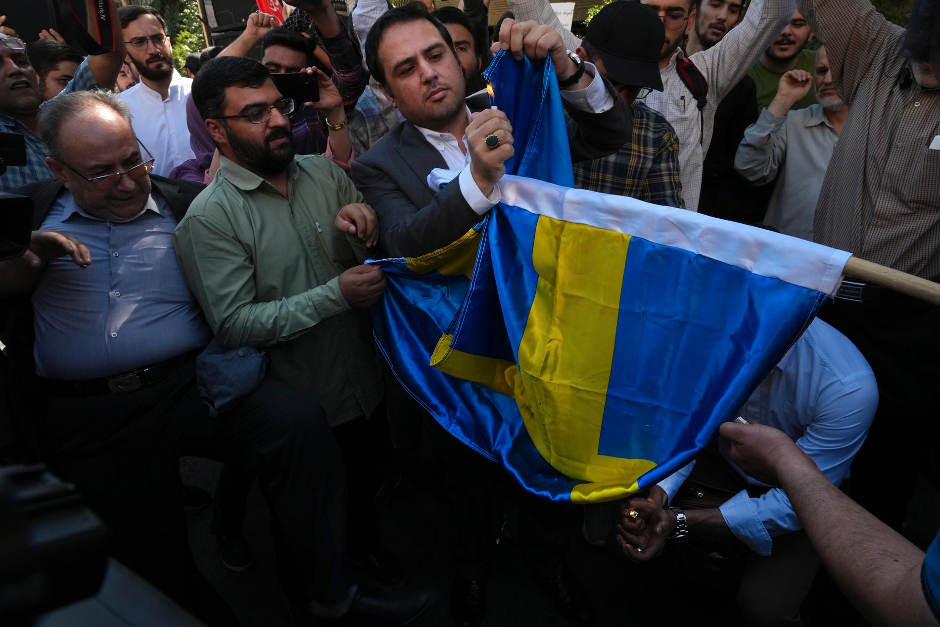 Iranska demonstranter bränner en svensk flagga utanför svenska ambassaden i Teheran. 