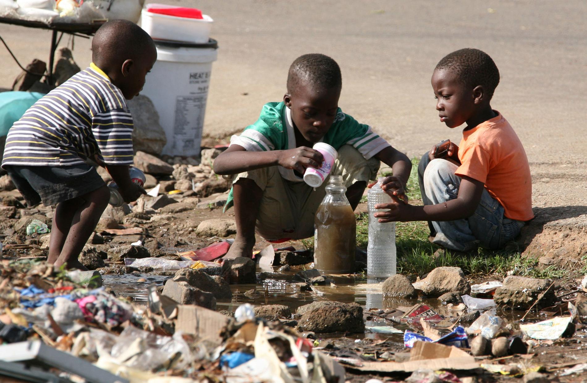 Barn i Zimbabwe fyller sina flaskor med smutsigt vatten. Arkivbild.