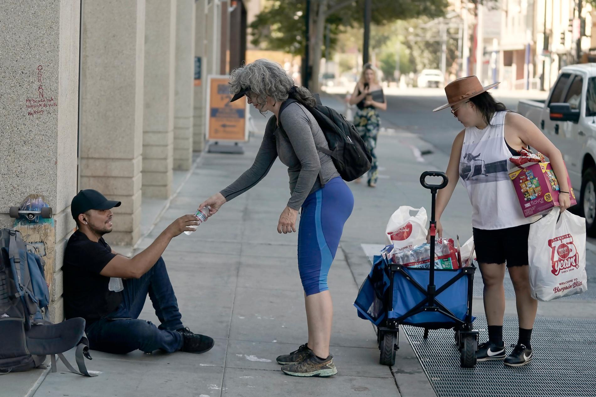 En kvinnan delar ut vatten till behövande på gatorna i Sacramento.