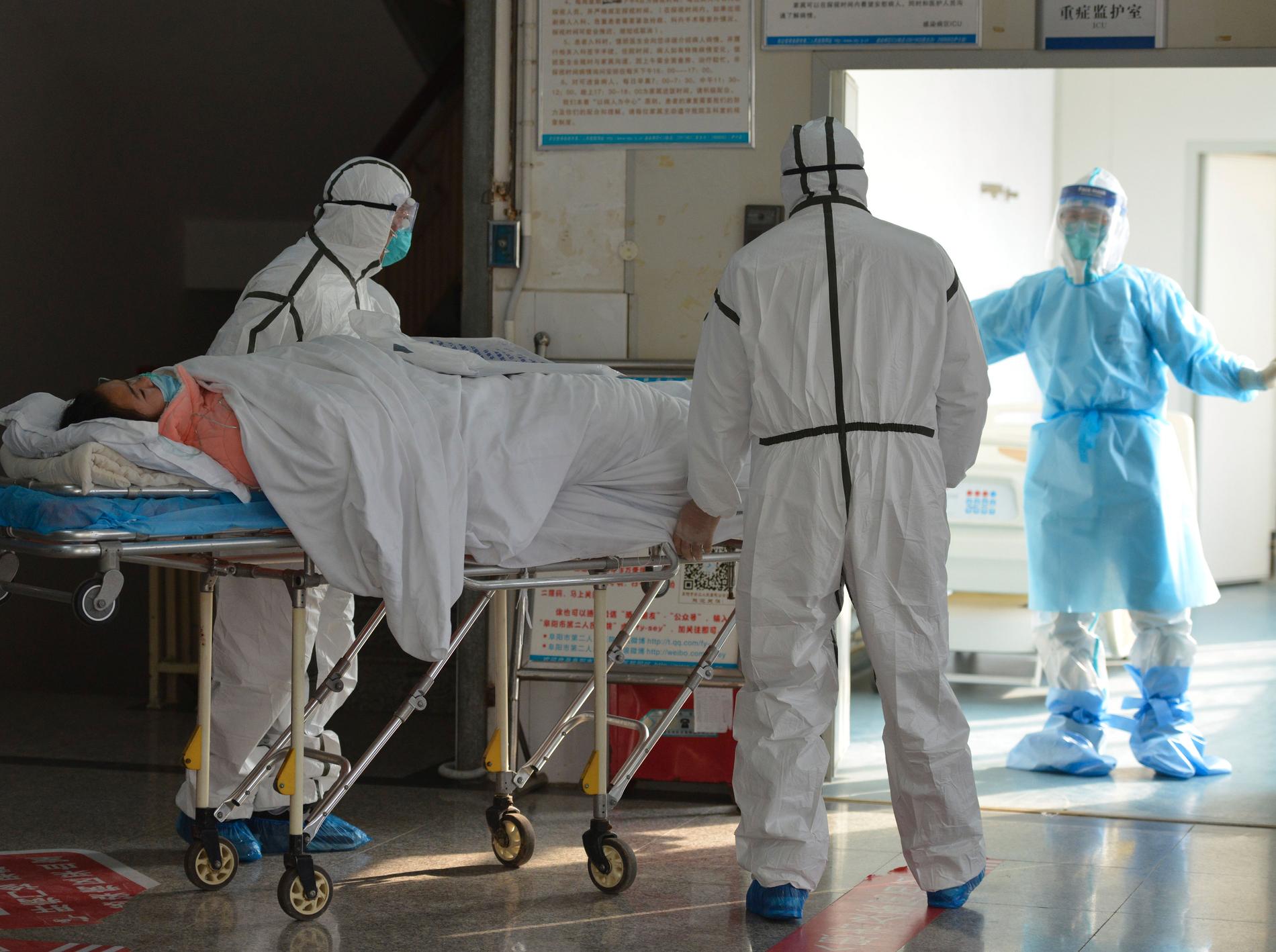 Kinesiska sjukvårdare flyttar en patient som smittats av det nya coronaviruset till en isolerad avdelning.