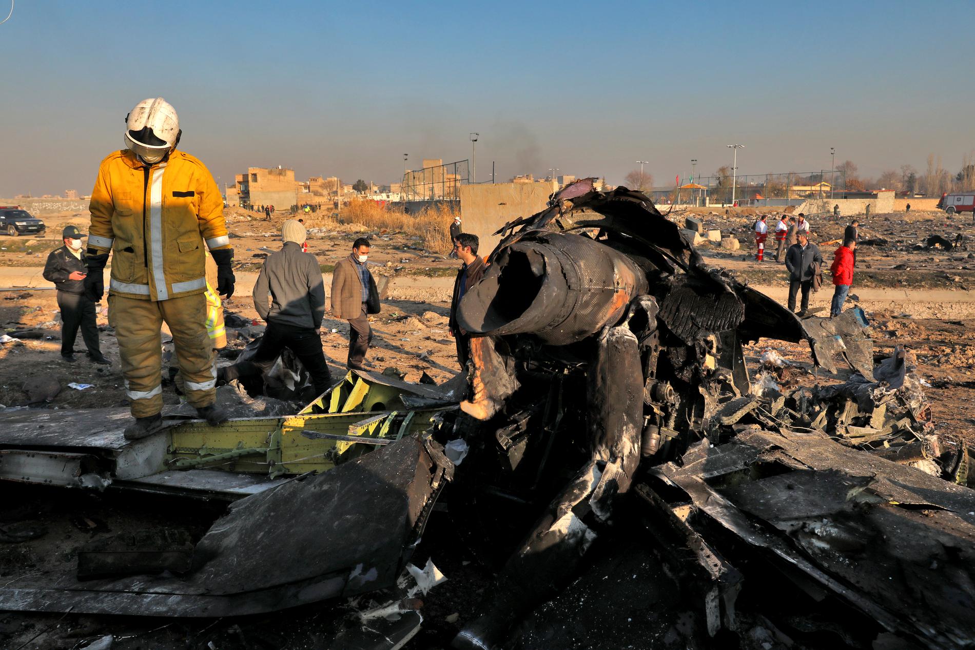 Räddningsarbetare på platsen där det ukrainska flygplanet störtade sedan det skjutits ned utanför Teheran den 8 januari.