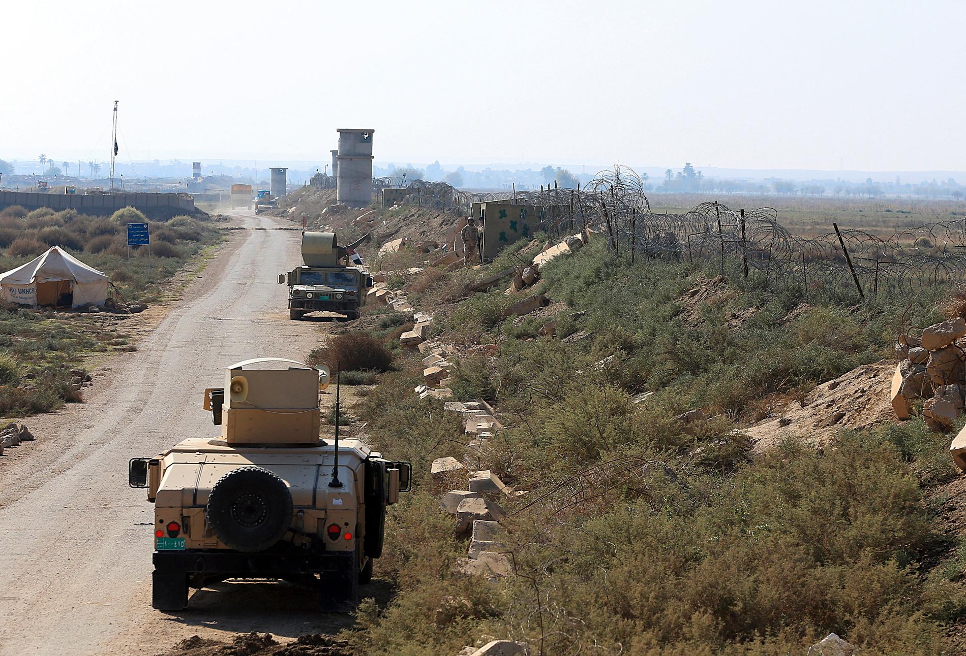 Irakiska soldater patrullerar längs med gränsen till Syrien i staden al-Qaim som befriades från IS för mer än ett år sedan.