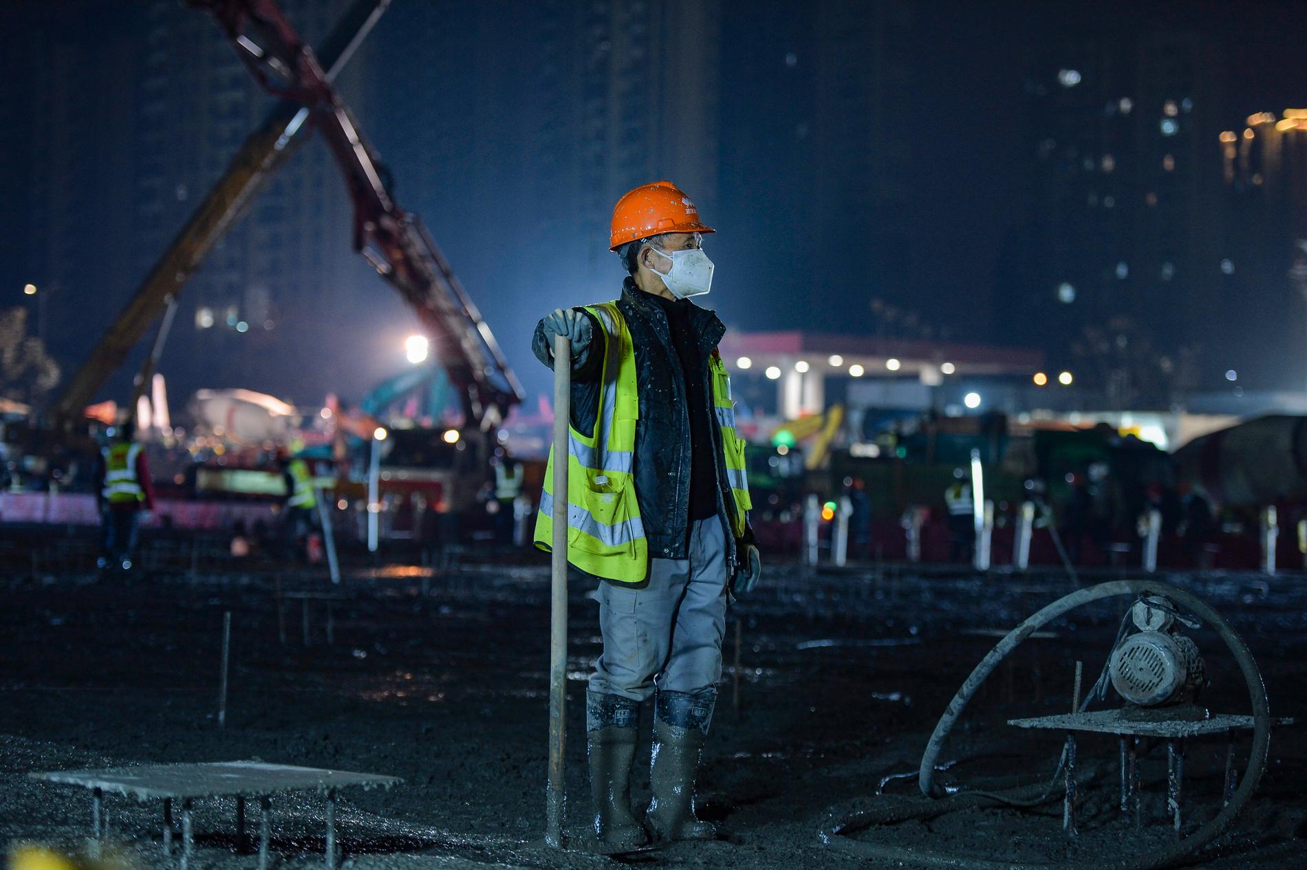 En byggnadsarbetare tar en kort rast vid bygget av ett av sjukhusen i Wuhan.