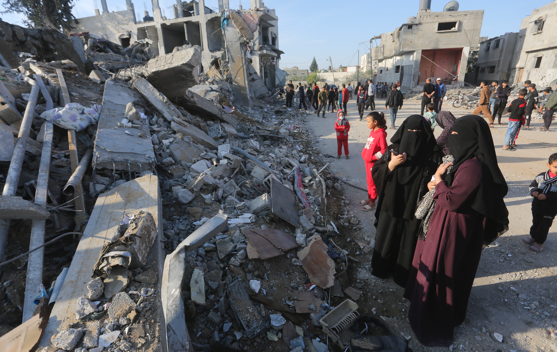 Palestinska kvinnor i Rafah tittar på förödelsen efter en israelisk attack. 