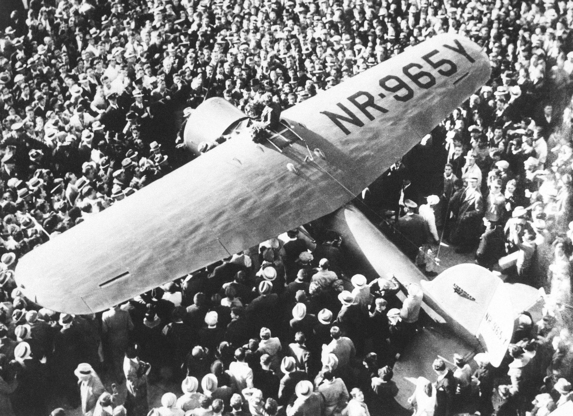  Amelia Earhart med sin Lockheed Vega omgiven av en folkmassa efter att hon blev den första kvinnan att flyga solo från Hawaii till Kalifornien 1935.