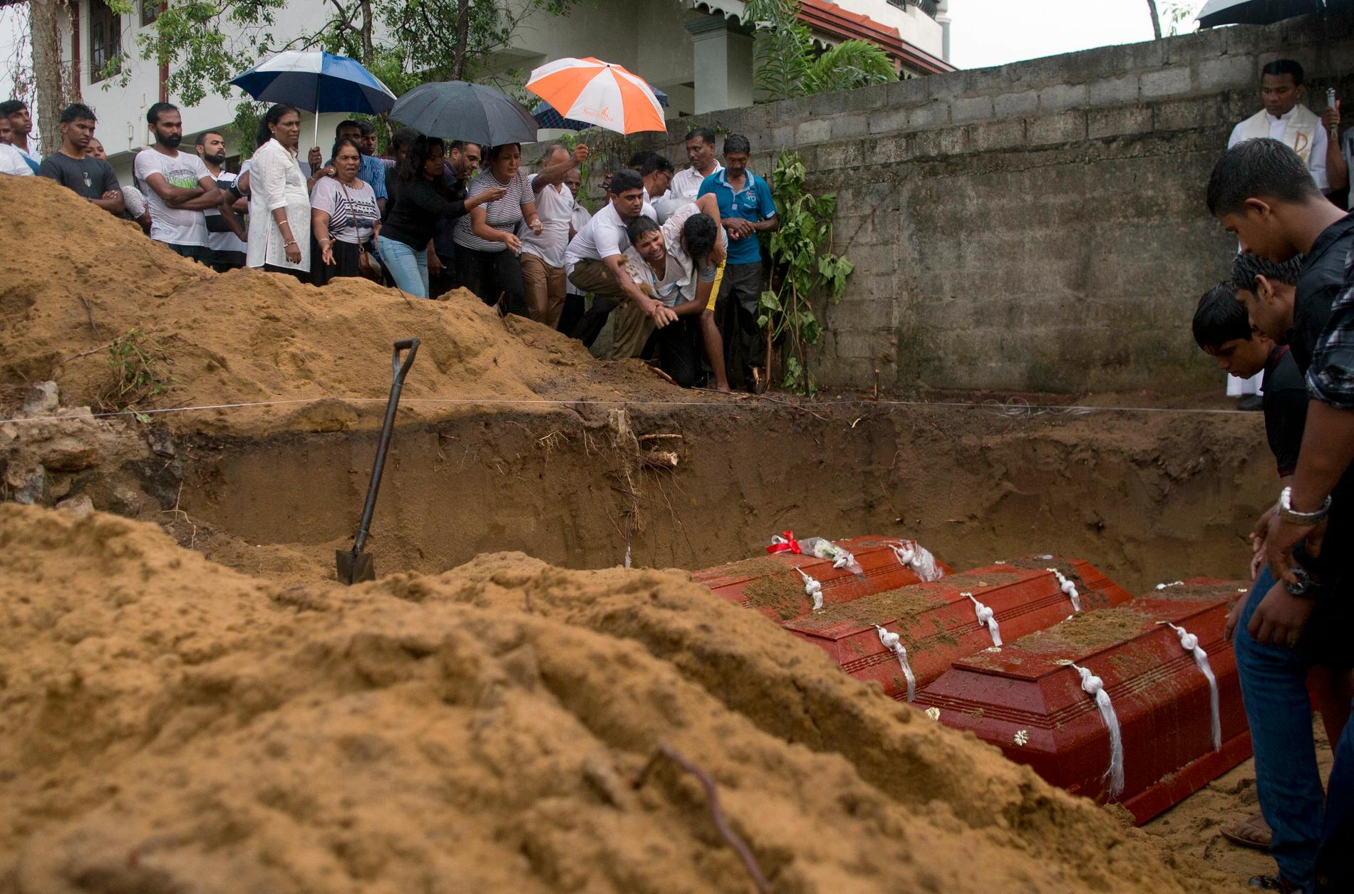 Anhöriga begraver tre familjemedlemmar – alla dog av bomben i St Sebastian Church i Negombo i söndags.