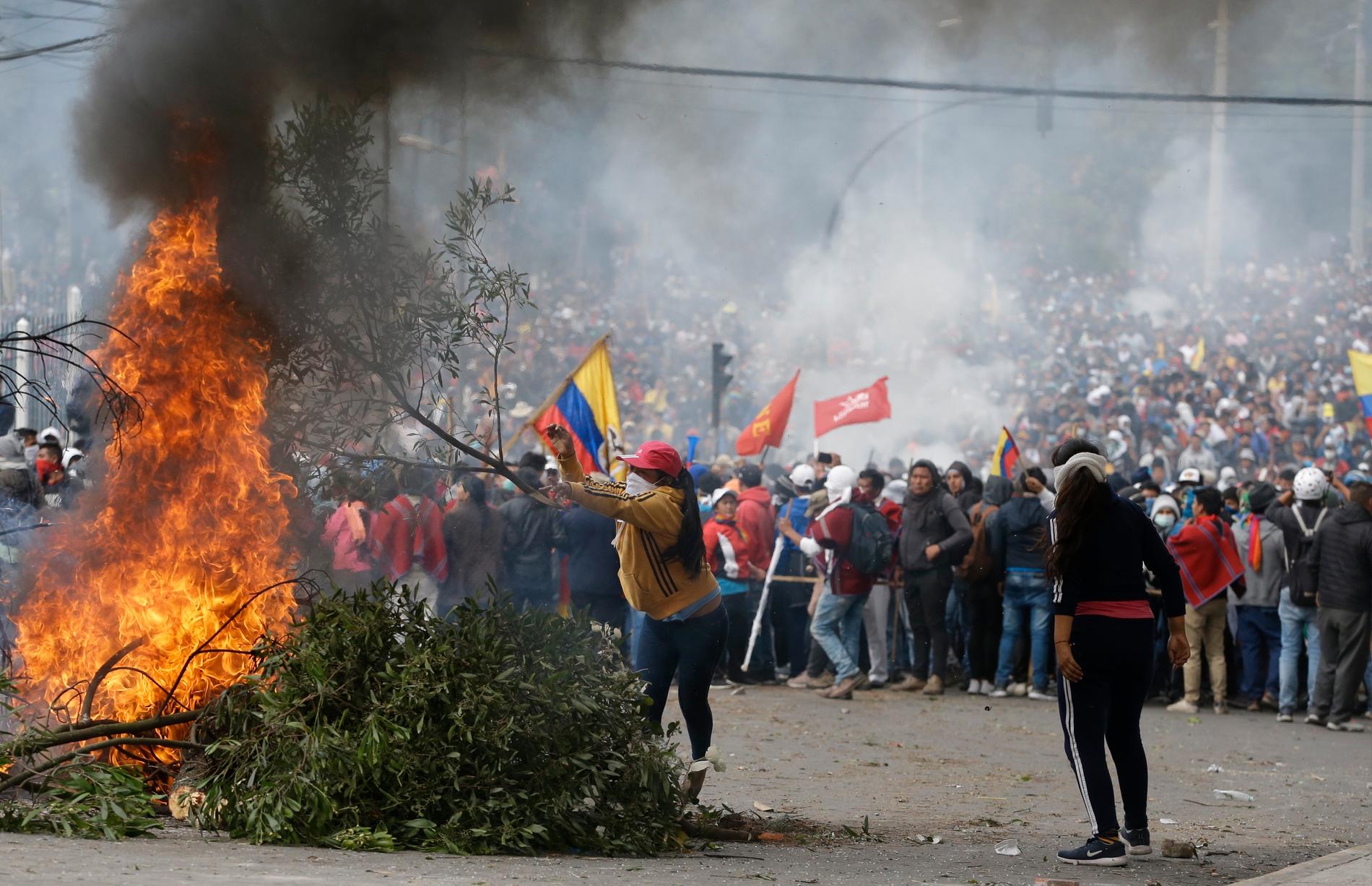 Demonstranter bränner en barrikad i Ecuadors huvudstad Quito.