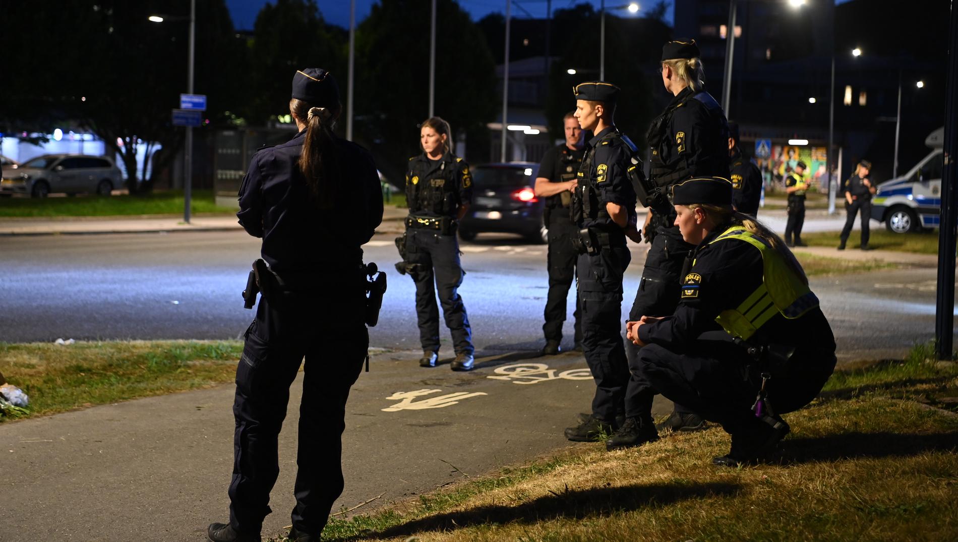 Många poliser är på plats i Biskopsgården. Insatsen fortsätter trots att mörkret fallit.