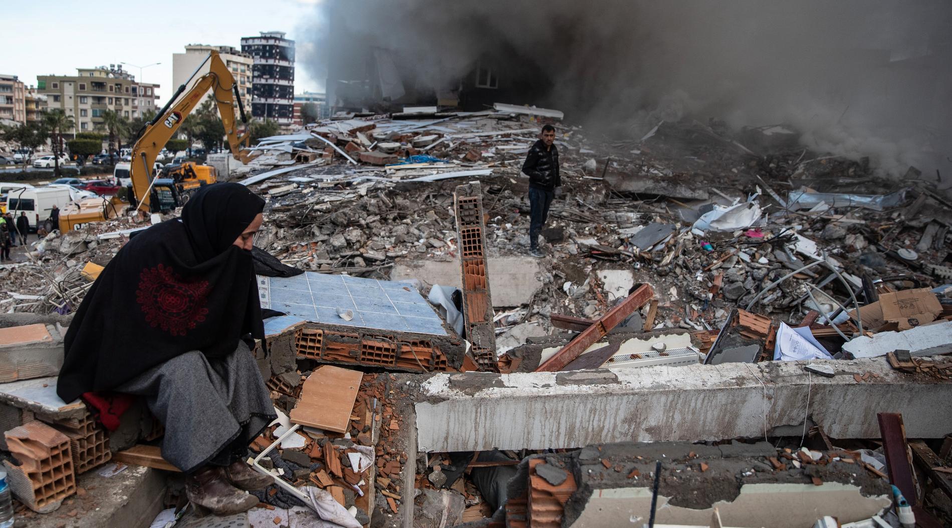 En kvinna väntar på besked på om hennes närstående överlevt i ruinerna efter en kollapsad byggnad. Den stora jordbävningen ägde rum natten till i måndags.
