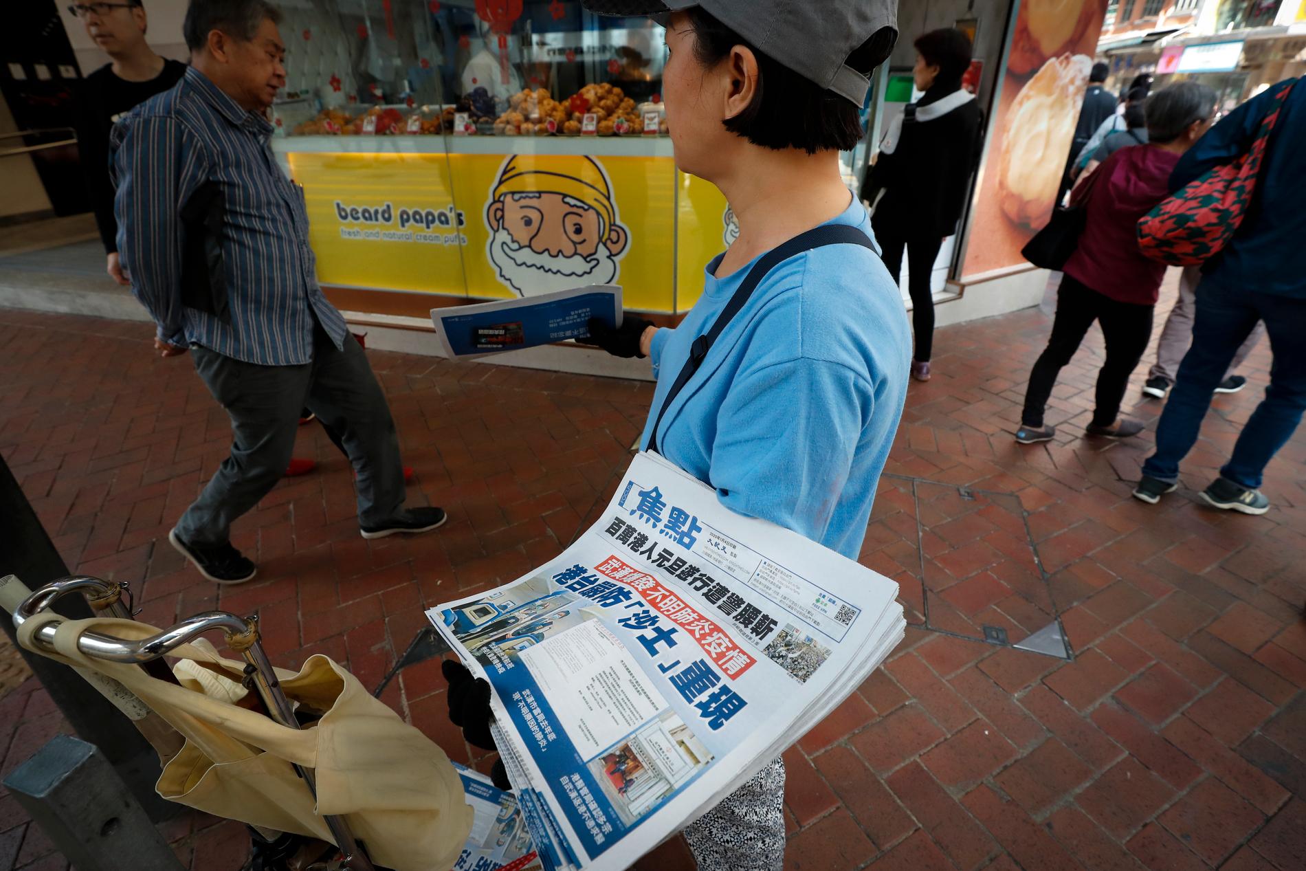 En säljare i Hongkong med tidningar med rubriker om det nya viruset. Arkivbild.