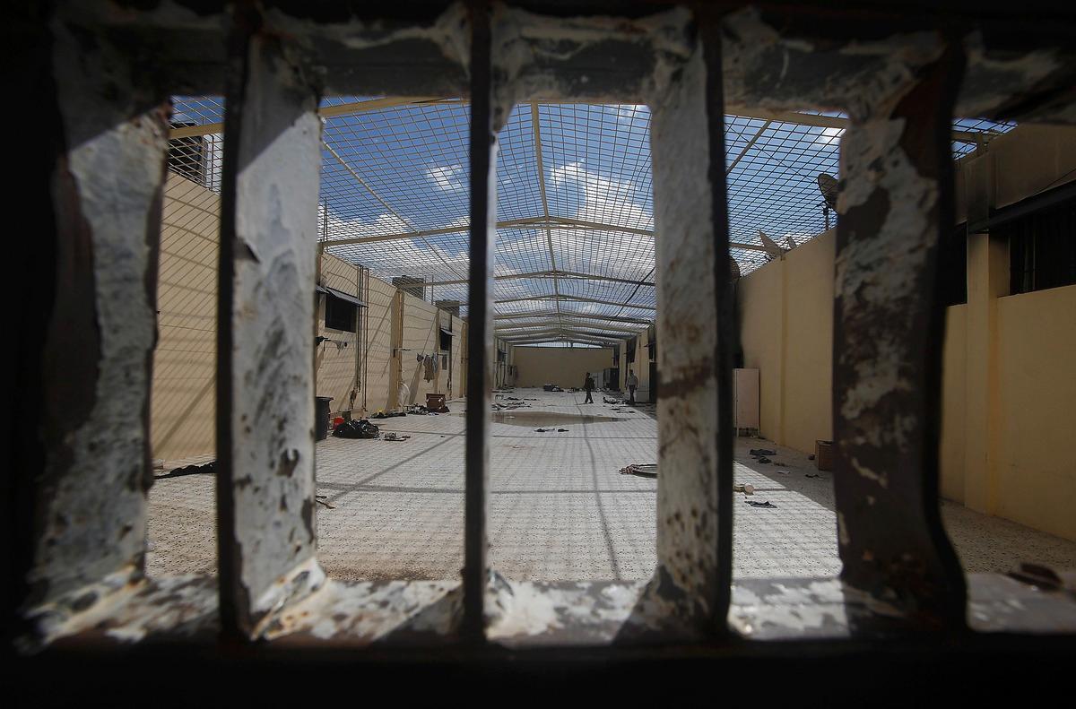 järnbur Några män undersökte en gallerförsedd innergård i Gaddafis utbrända huvudfängelse i staden Benghazi i går.