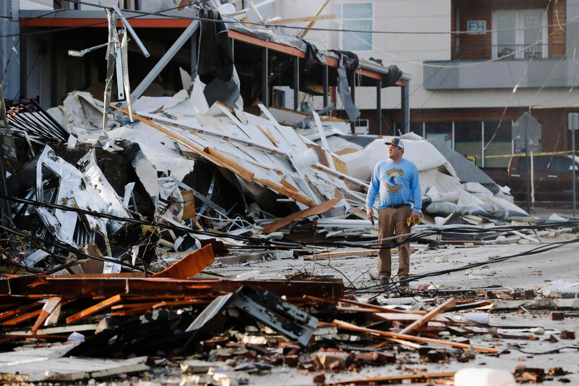 En man tittar på rasmassorna av hus som kollapsat i Nashville.