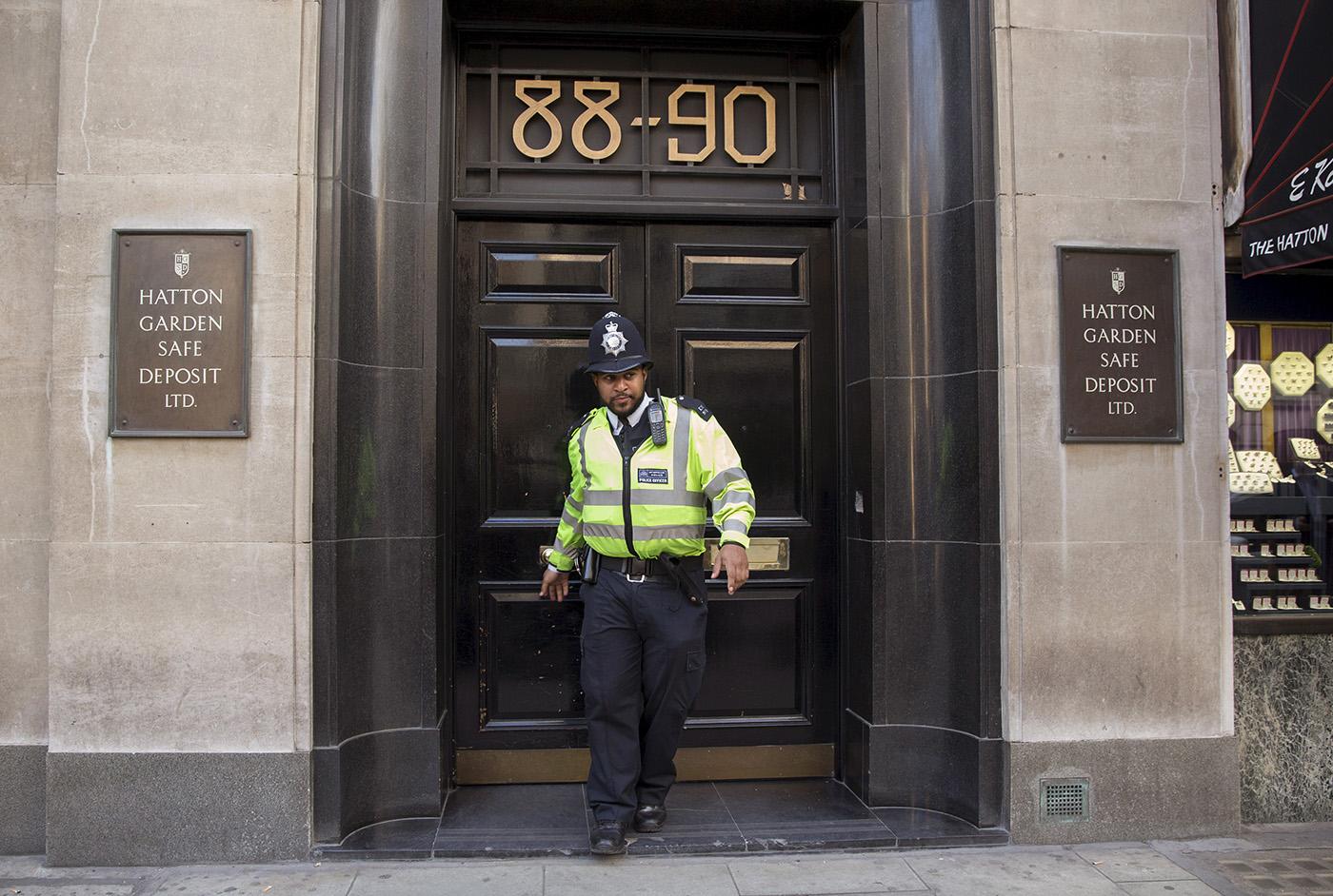 En polis kommer ut från Hatton Garden, där runt 70 bankfack plundrats under påskhelgen.