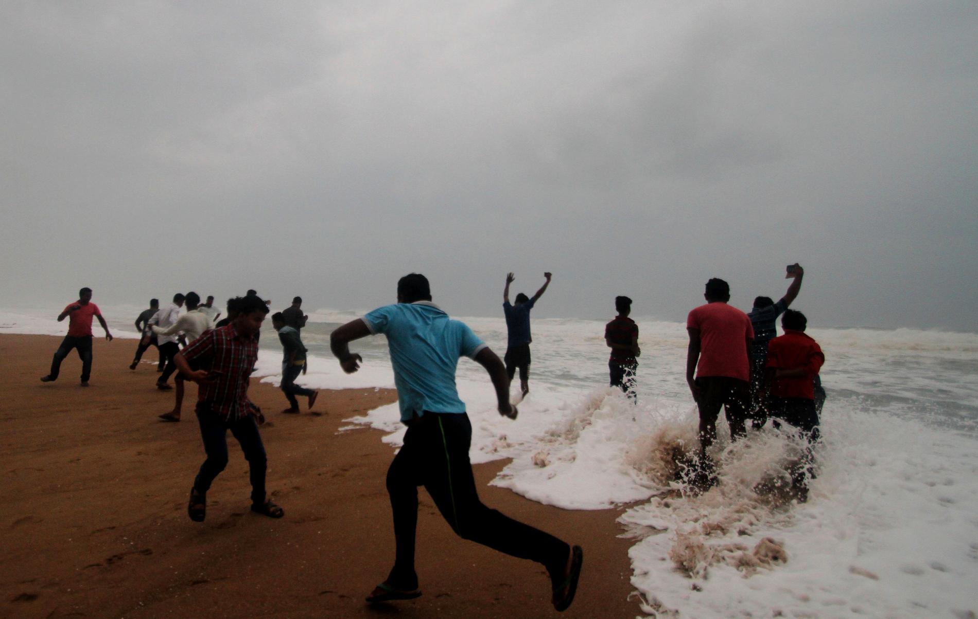 Människor i vågor på en strand i Odisha.