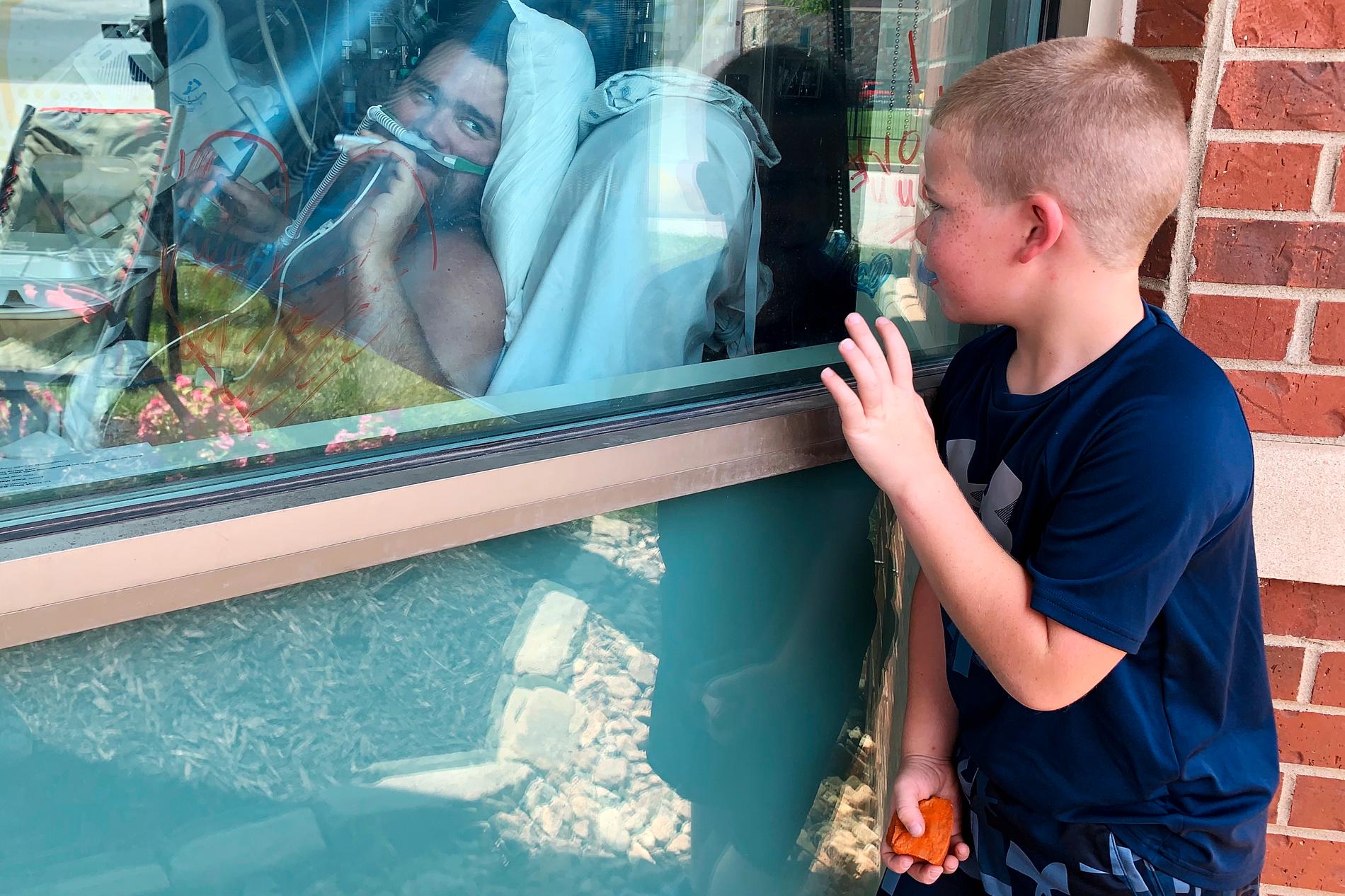 Sexårige Brody Barker vinkar till sin pappa Daryl, som vårdas för covid-19 på ett sjukhus i Missouri.