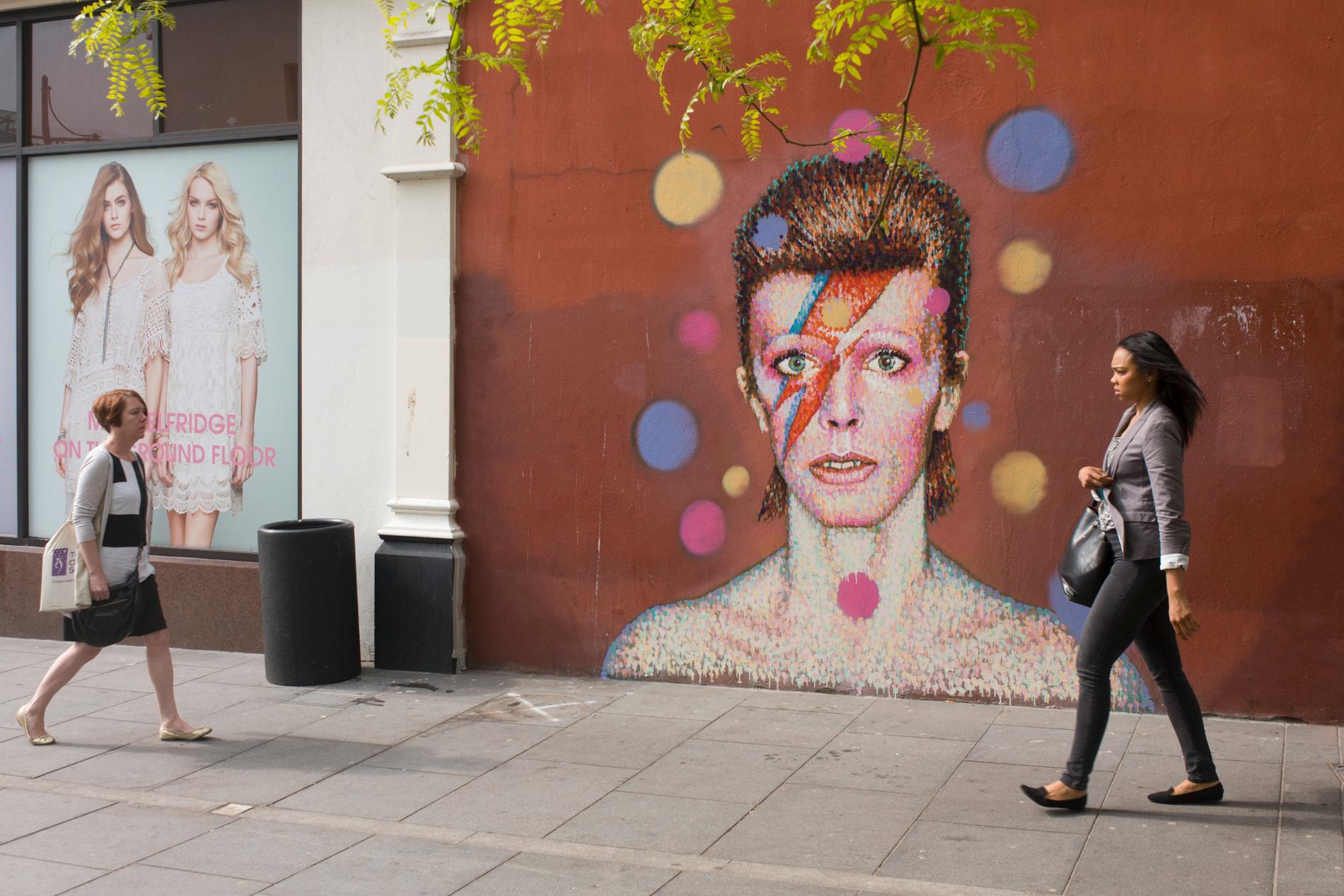 David Bowie på en muralmålning i Brixton, södra London. The Bowie face is sourced (by an unknown artist) from the cover of his 1973 album Aladdin Sane at the height of his 1970s fame. The pop icon lived at 40 Stansfield Road, Brixton, from his birth in 1947 until 1953. This cover appeared in Rolling Stone’s list of the 500 greatest albums of all time, making #277.