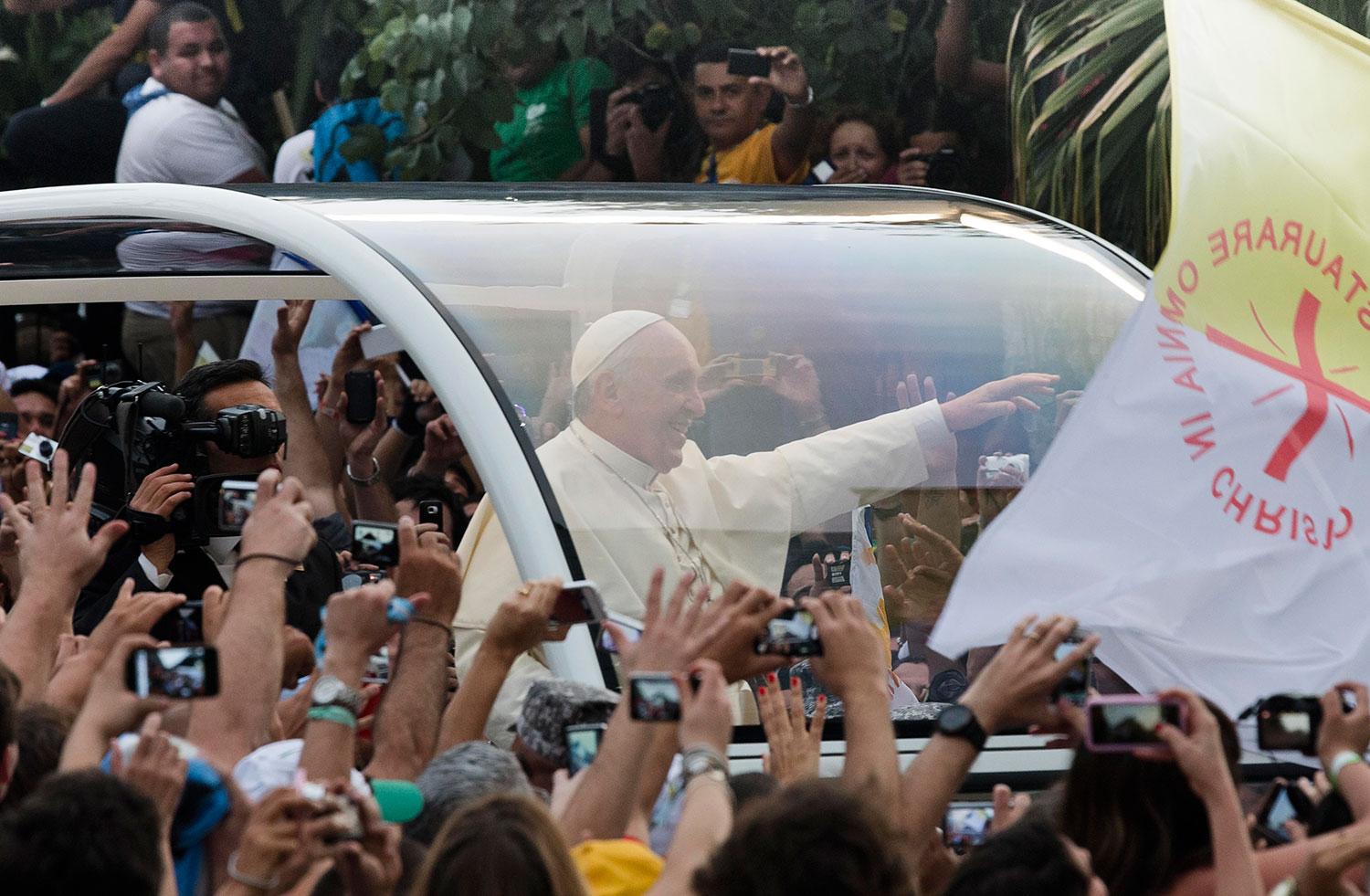 VINKAR FRÅN PÅVEMOBILEN Påven Franciskus vinkar från sin påvemobil i Rio de Janeiro i Brasilien under ett besök i maj 2013.