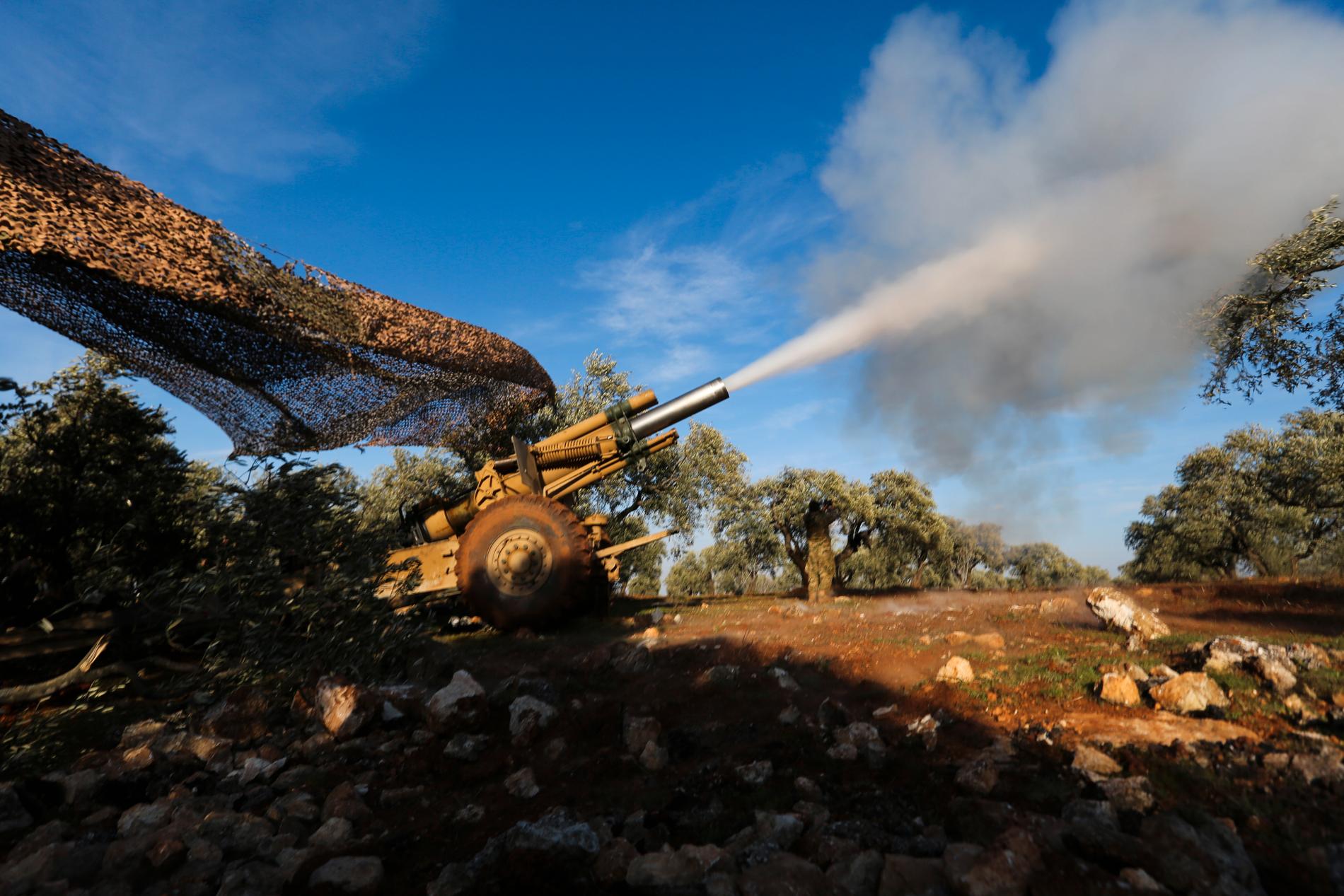 Turkietstödda rebellsoldater ger artillerield mot regimposteringar nära byn Neirab i Idlib. Bilden är tagen på torsdagen.