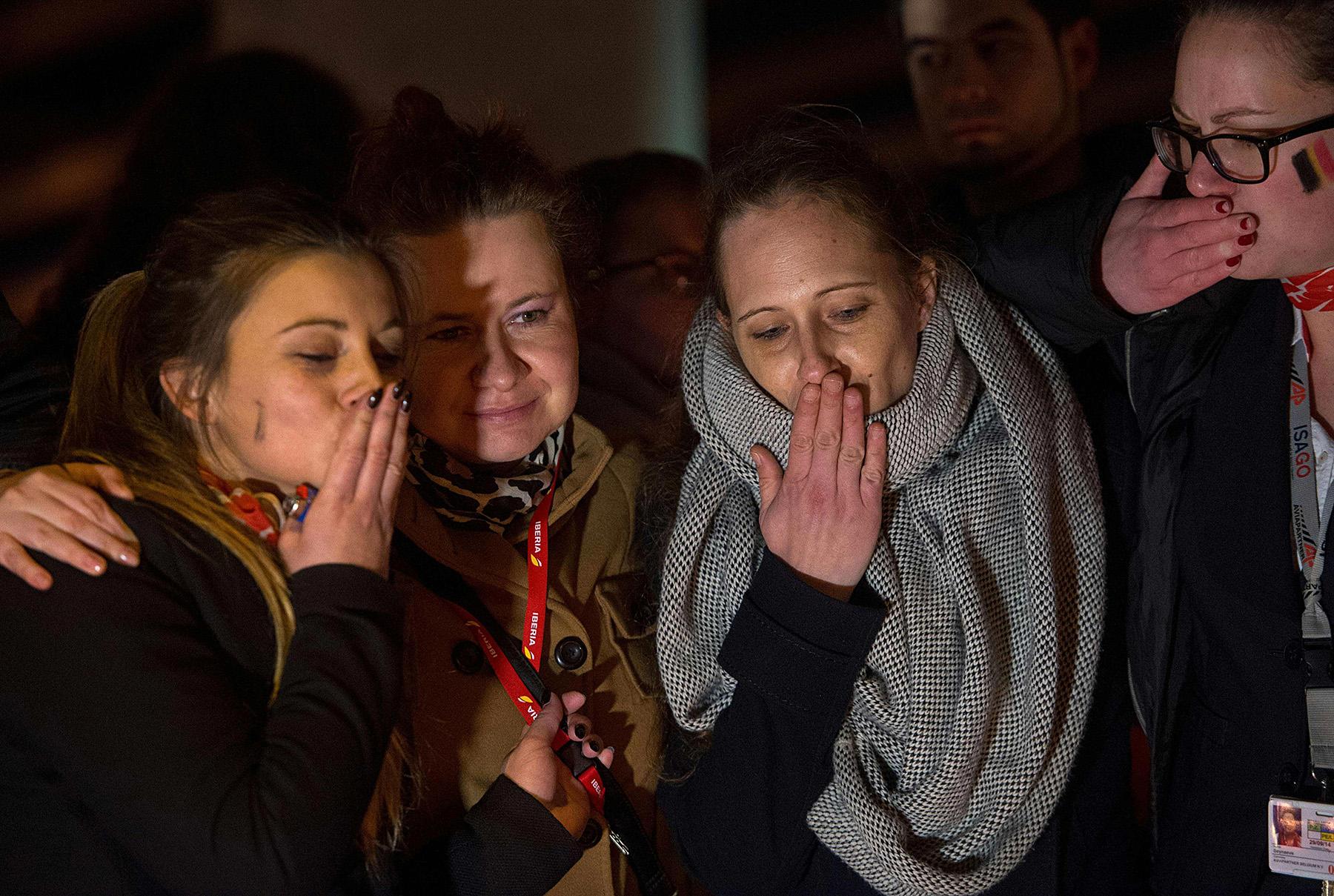 Flygplatsanställda hedrar offren för terroratackerna vid en ceremoni nära flygplatsen Zeventem på onsdagskvällen.