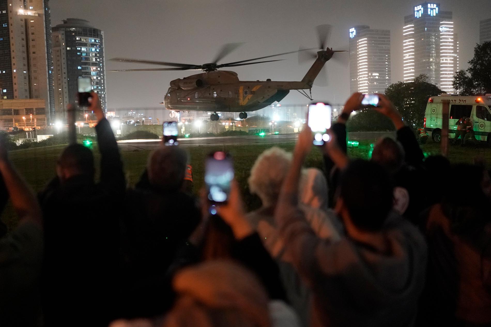 Israeler väntar otåligt på en helikopter med landsmän som hållits gisslan av terrorstämplade Hamas i Gaza. Helikoptern är på väg att land vid ett sjukhus i Petah Tikva i Israel. Bilden togs i söndags.