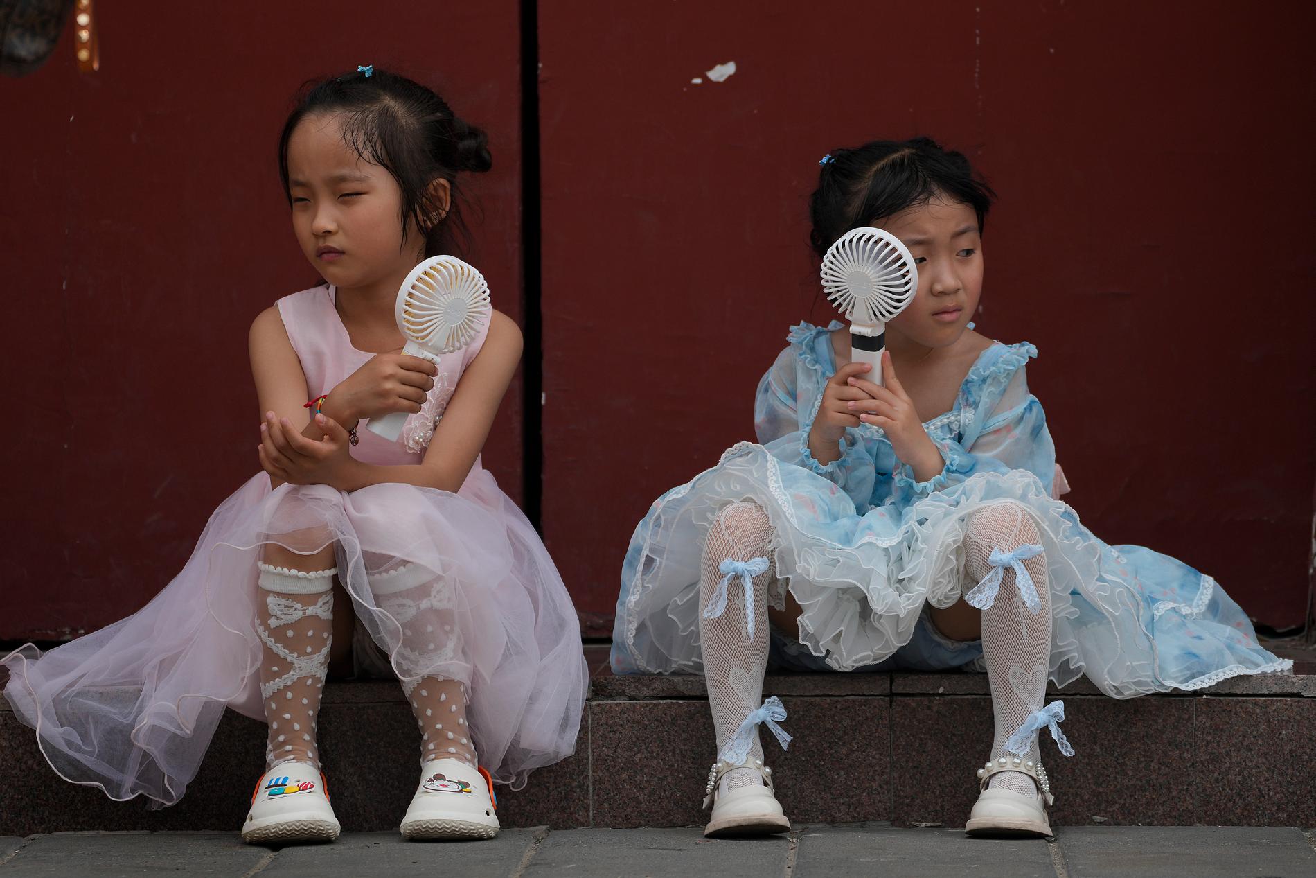 Barn försöker svalka sig i hettan i Peking.