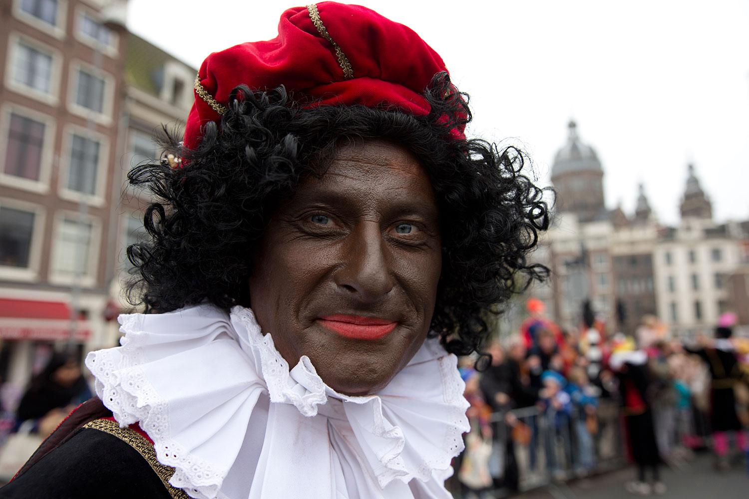 En svartmålad ”Zwarte Piet” i en parad i Amsterdam.