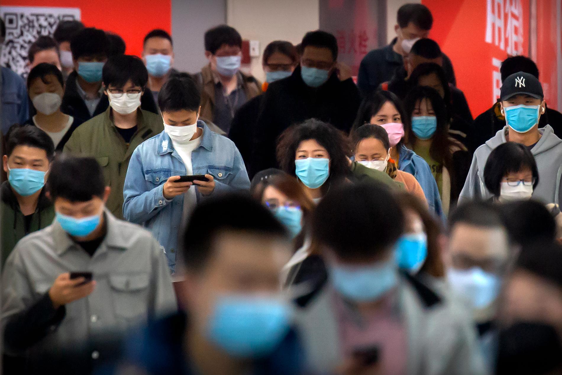 Resenärer med munskydd i Pekings tunnelbana.