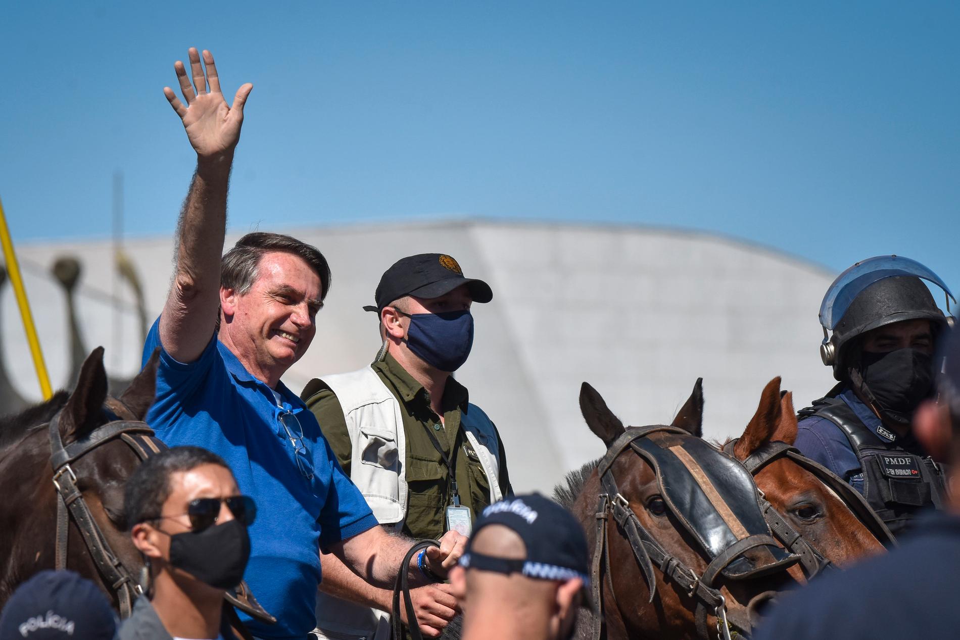 Brasiliens president Jair Bolsonaro till häst möter anhängare utanför presidentpalatset i huvudstaden Brasilia.