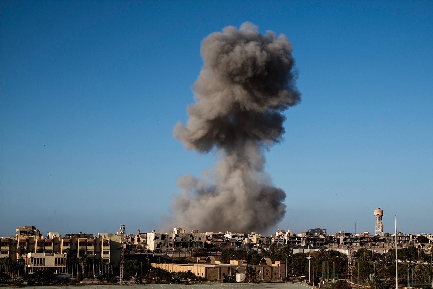 Rök stiger mot himlen efter att en granat slagit ner i hamnstaden Sirte