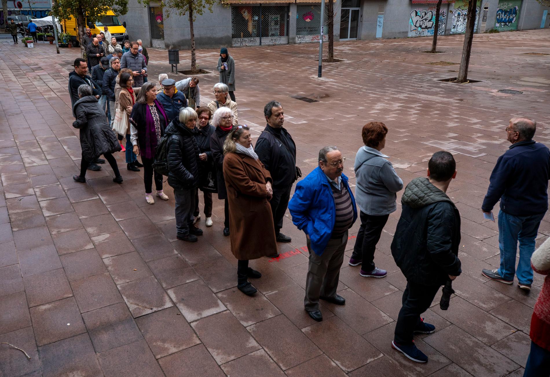 Väljare på kö utanför en vallokal i Barcelona på söndagen.