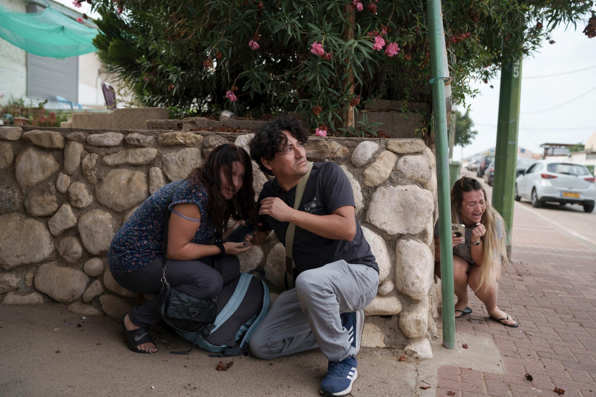 Människor i Ashkelon, södra Israel, tar skydd från raketbeskjutning. När den här bilden togs, 11 oktober, hade tusentals människor dött på bägge sidor, även civila.
