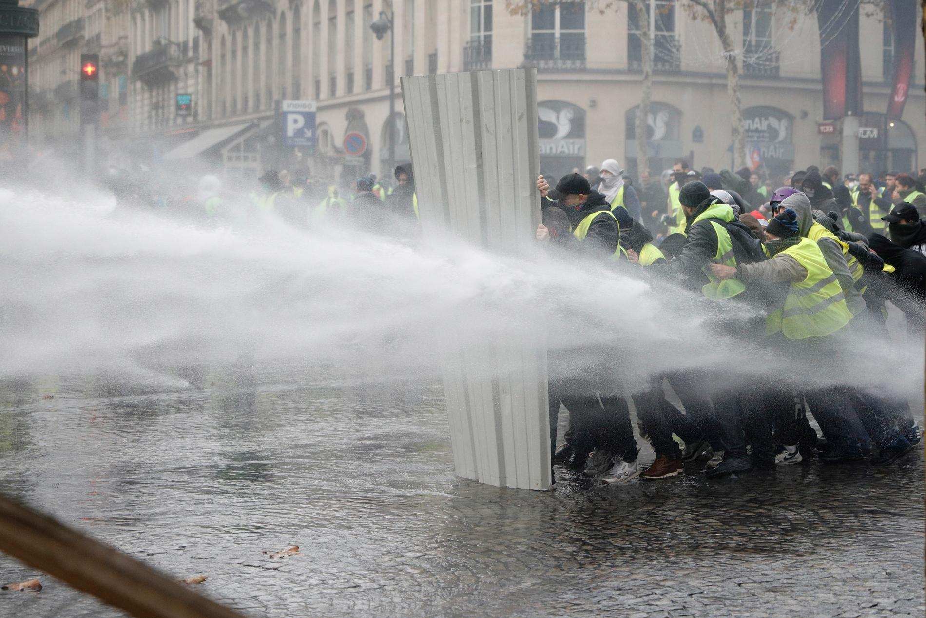 Polis använder vattenkanoner mot demonstranter i Paris.