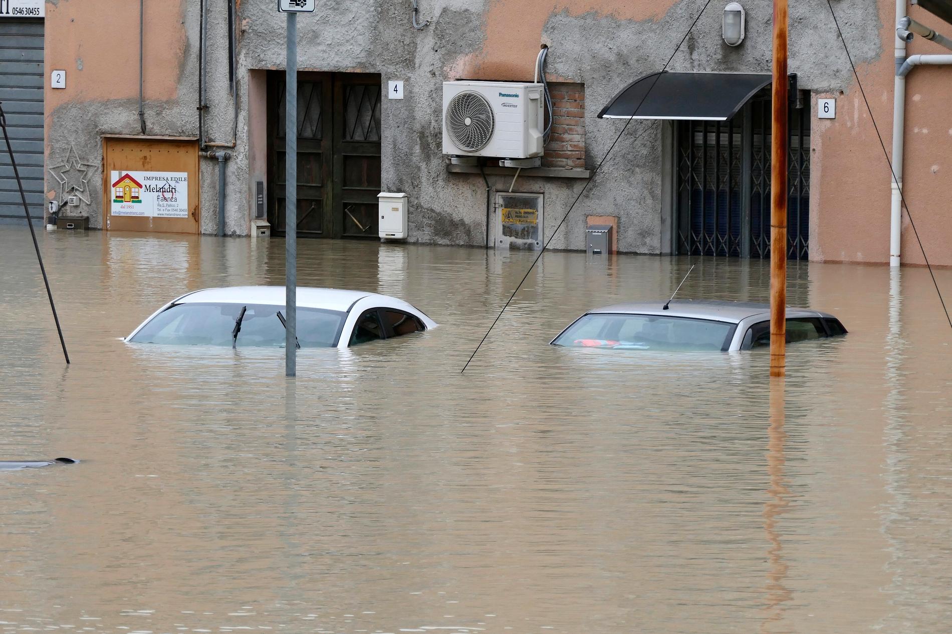 Bilar dränkta av vattenmassor i den italienska staden Faenza. 
